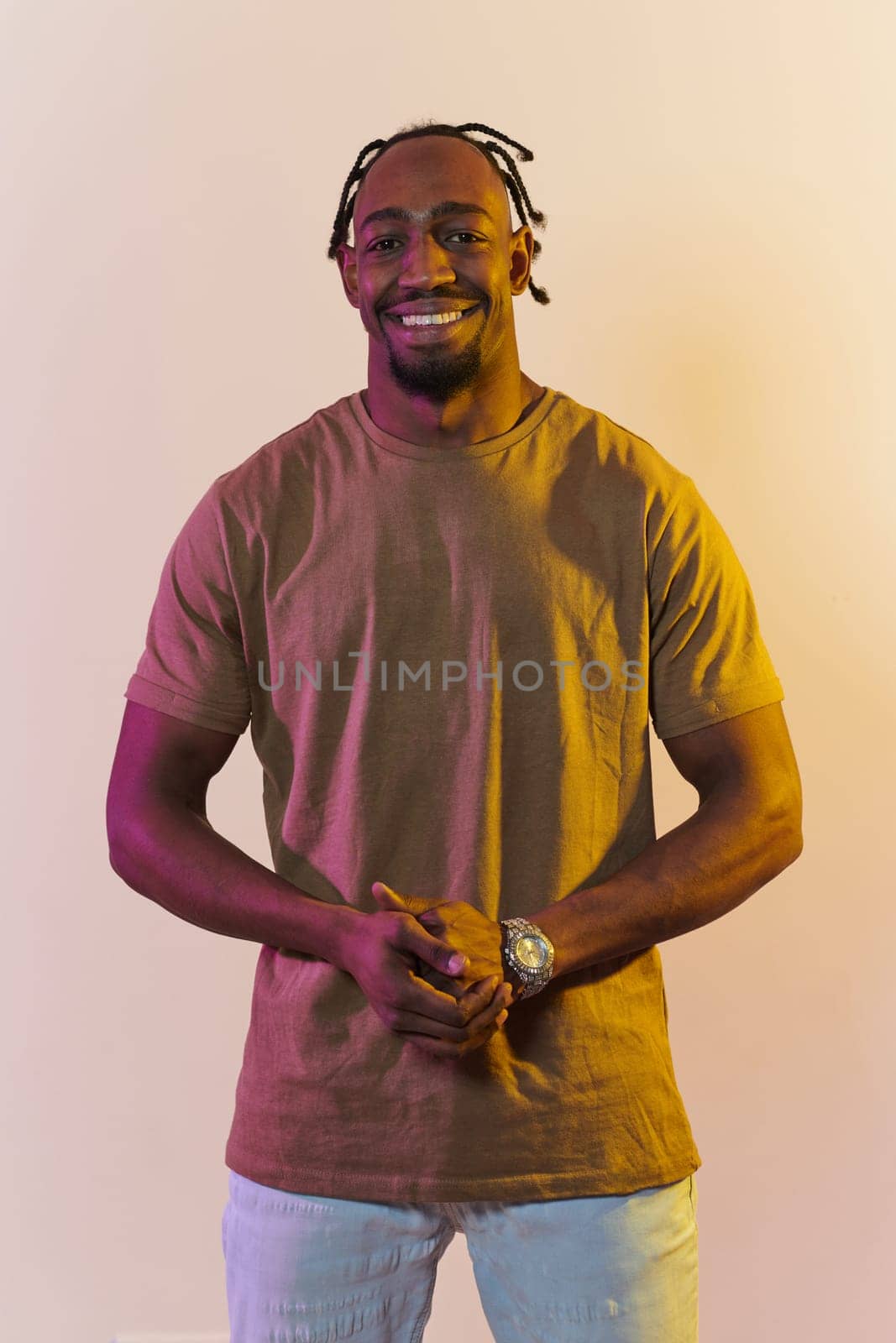 A charismatic and stylish African American man commands attention against a vibrant yellow gel background, showcasing his confident and contemporary fashion sense, radiating charm and sophistication in a striking portrait by dotshock