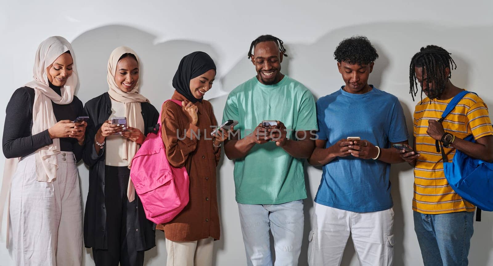 A diverse group of students, immersed in the digital age, stands united while engaging with their smartphones against a white backdrop, symbolizing the modern era of connectivity, communication, and collaborative learning by dotshock
