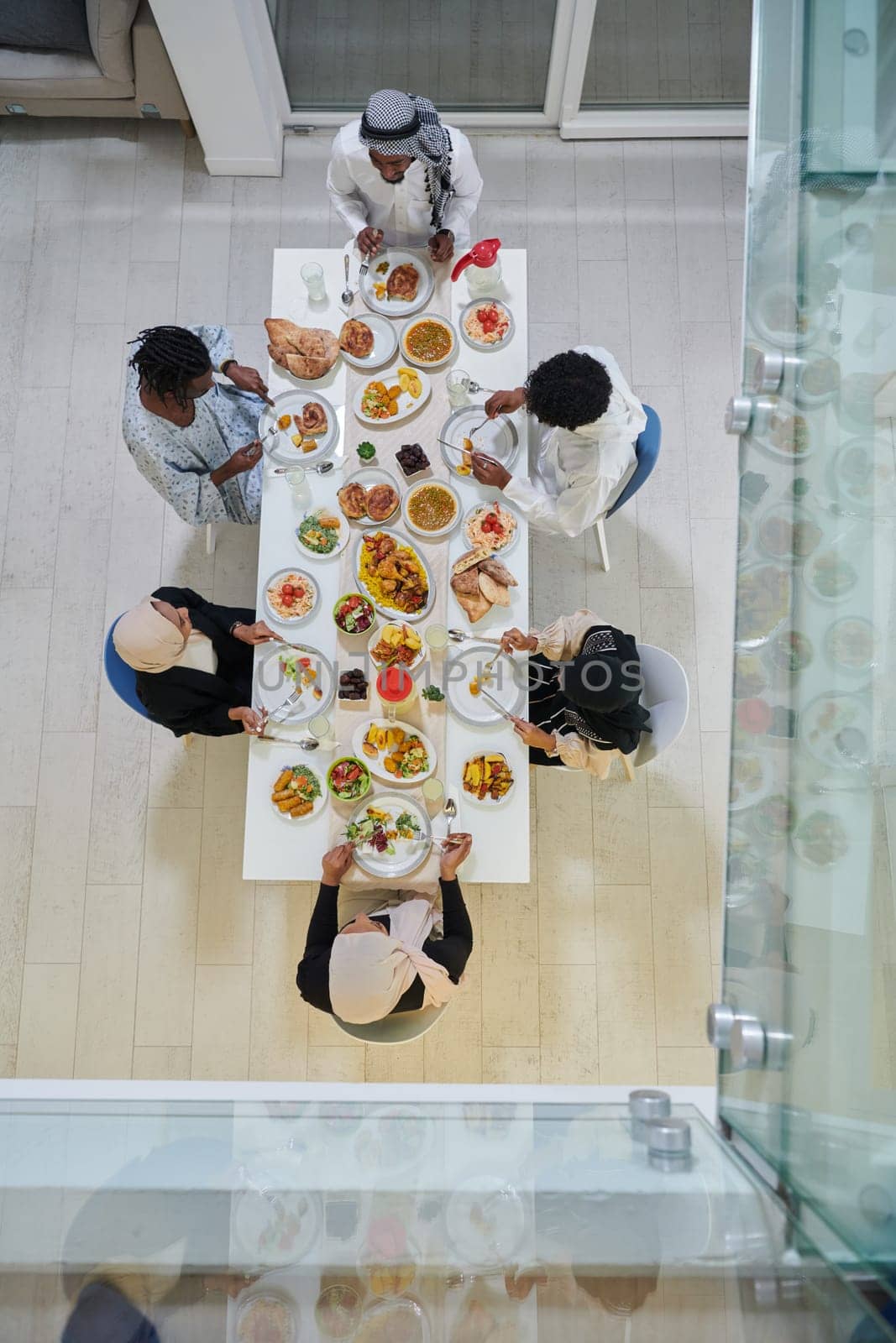 Top view of traditional and diverse Muslim family comes together to share a delicious iftar meal during the sacred month of Ramadan, embodying the essence of familial joy, cultural richness, and spiritual unity in their shared celebration by dotshock