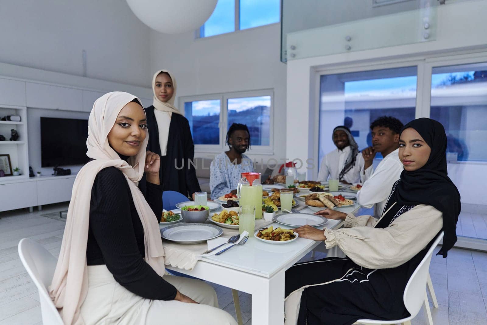 In the sacred month of Ramadan, a Muslim family joyously comes together around a table, eagerly awaiting the communal iftar, engaging in the preparation of a shared meal, and uniting in anticipation of a collective prayer, embodying the spirit of togetherness, devotion, and cultural celebration by dotshock