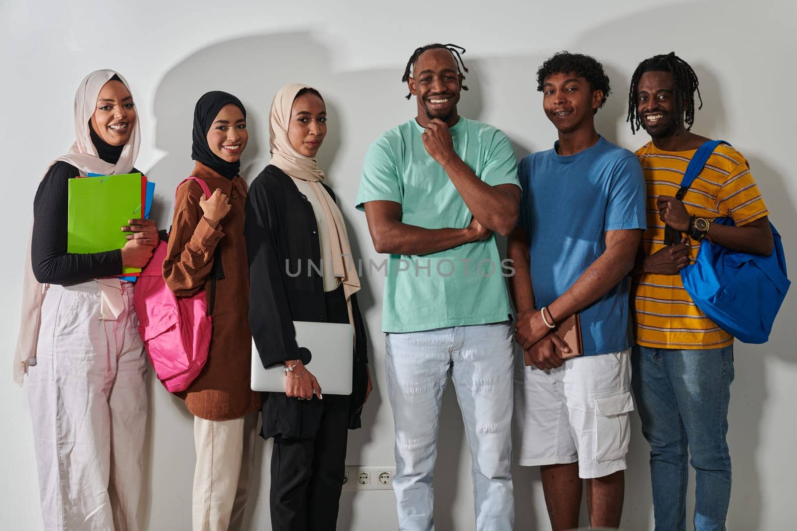 In a vibrant display of educational diversity, a group of students strikes a pose against a clean white background, holding backpacks, laptops, and tablets, symbolizing a blend of modern technology, unity, and cultural inclusivity in their academic journey by dotshock