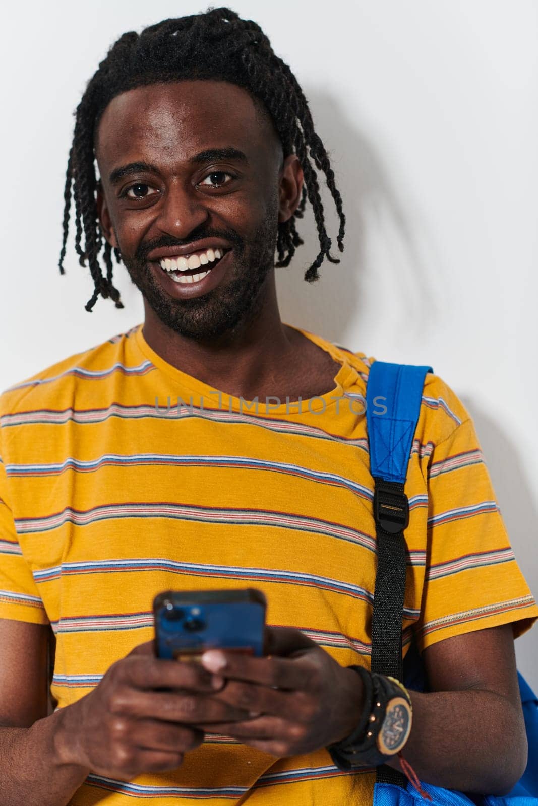 African American teenager engages with his smartphone against a pristine white background, encapsulating the essence of contemporary digital connectivity and youth culture by dotshock