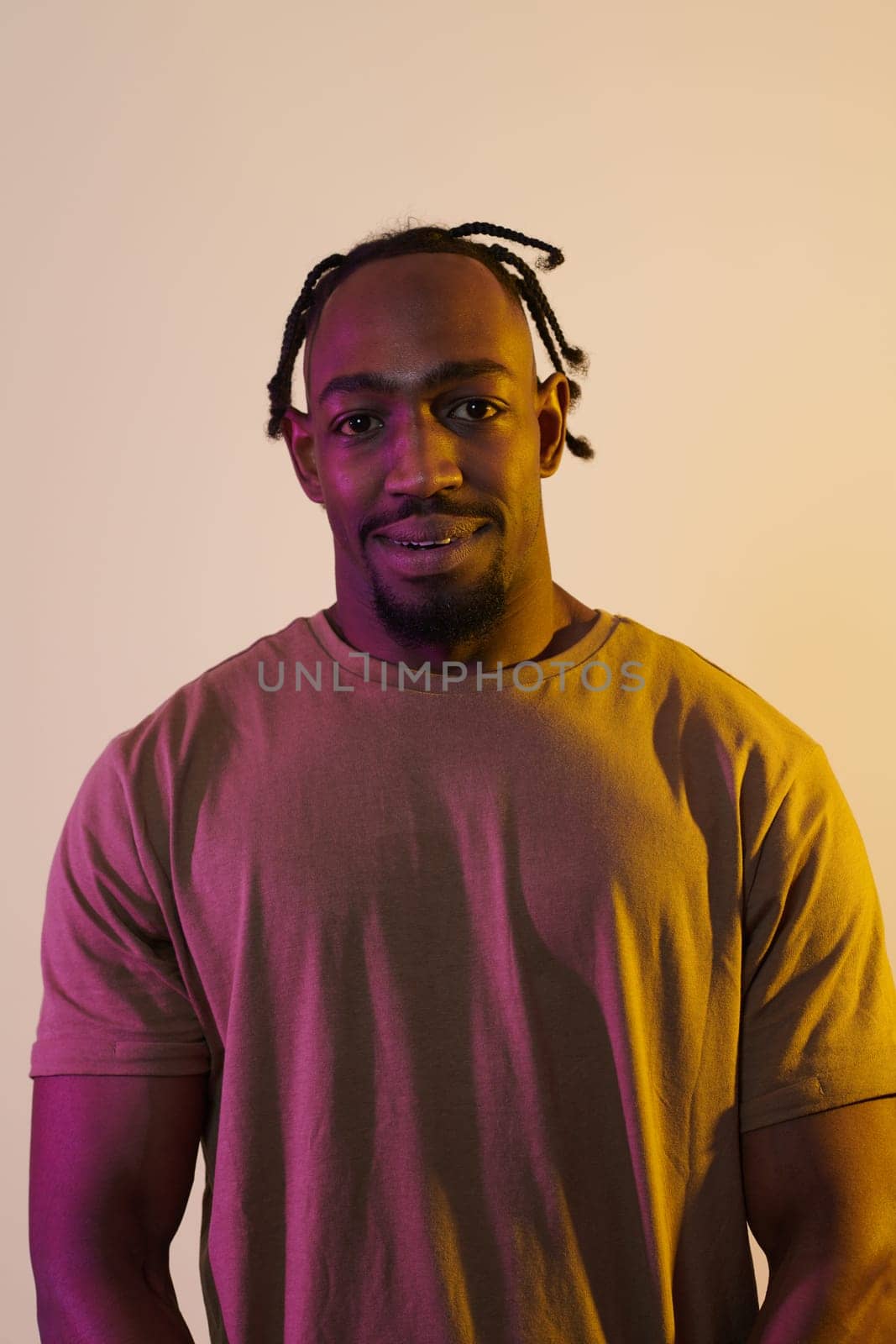 A charismatic and stylish African American man commands attention against a vibrant yellow gel background, showcasing his confident and contemporary fashion sense, radiating charm and sophistication in a striking portrait by dotshock