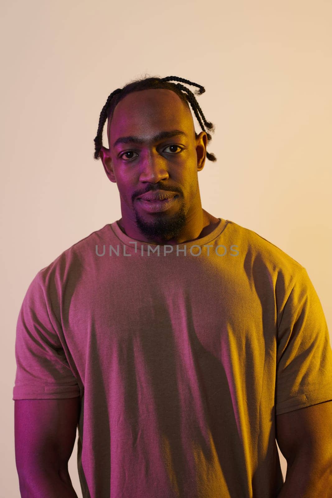 A charismatic and stylish African American man commands attention against a vibrant yellow gel background, showcasing his confident and contemporary fashion sense, radiating charm and sophistication in a striking portrait by dotshock