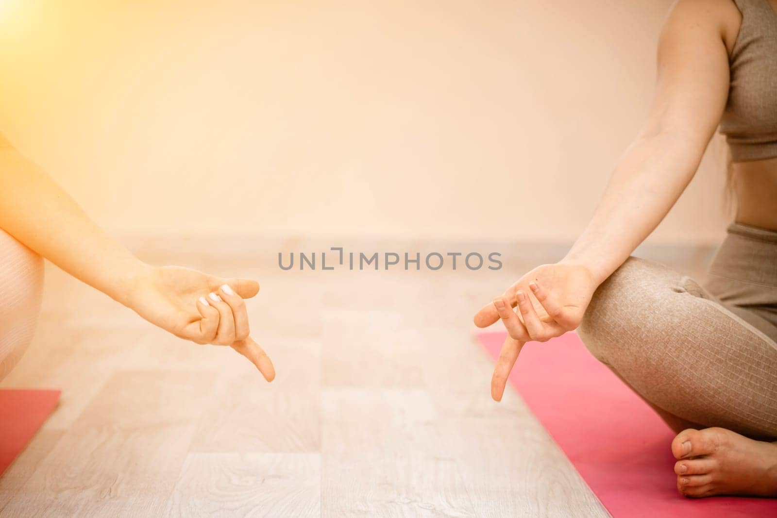 Two beautiful women do yoga, sports in the gym. The concept of grace and beauty of the body. by Matiunina