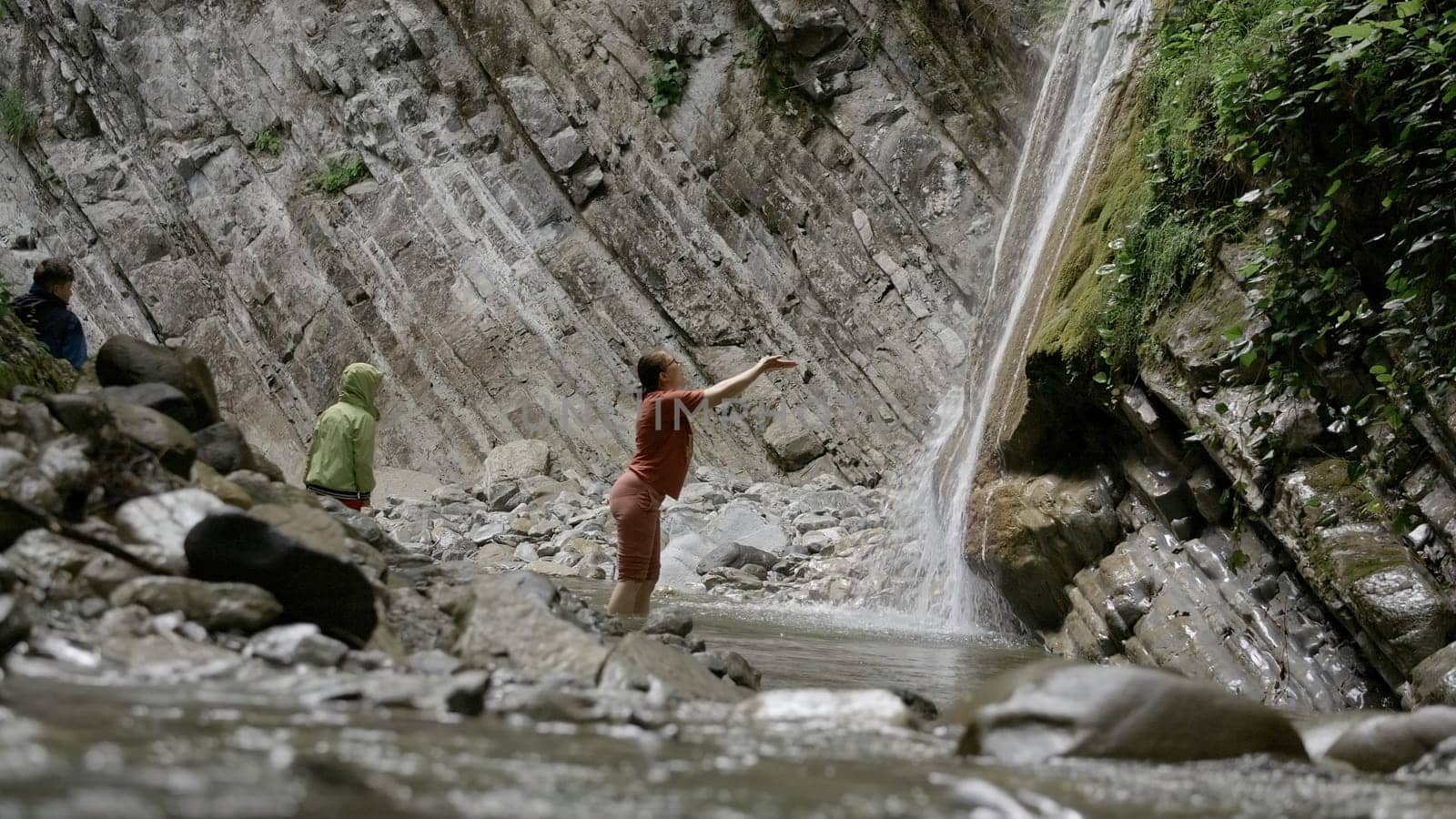 A mother and her son swimming in a mountain creek in northern Sweden. Creative. Concept of summer vacation, cold water stream among rocks