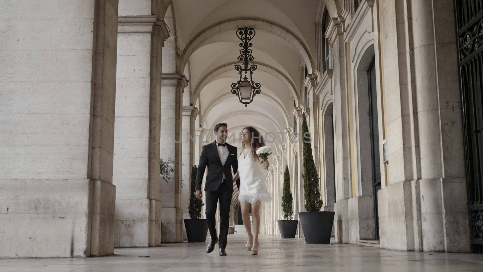 A walking couple of running newlyweds. Action. A large castle next to which people are running with flowers and happy faces in wedding dresses. High quality 4k footage