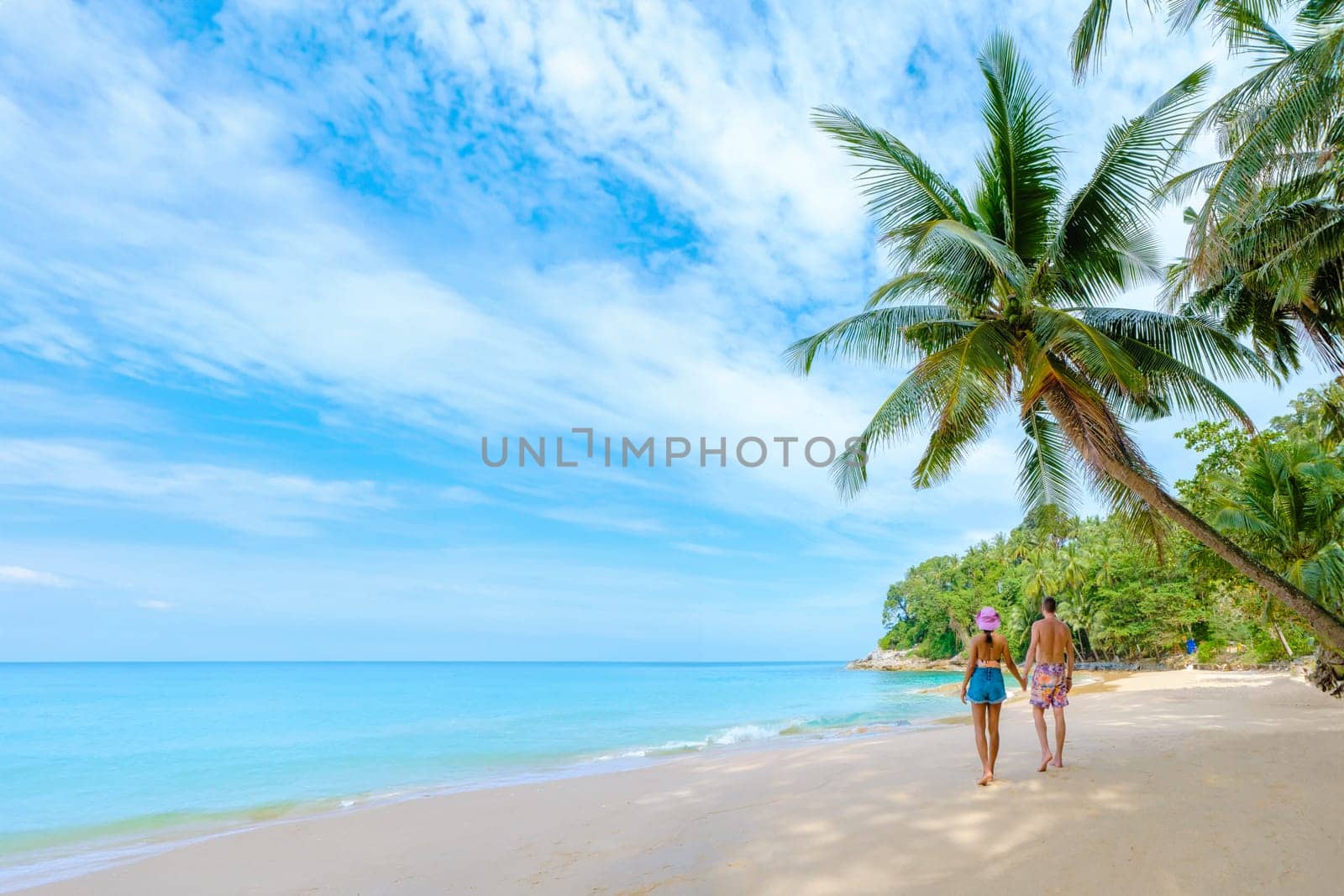 Phuket Thailand, a couple of men and woman walking at the beach of Surin, Surin Beach Phuket by fokkebok