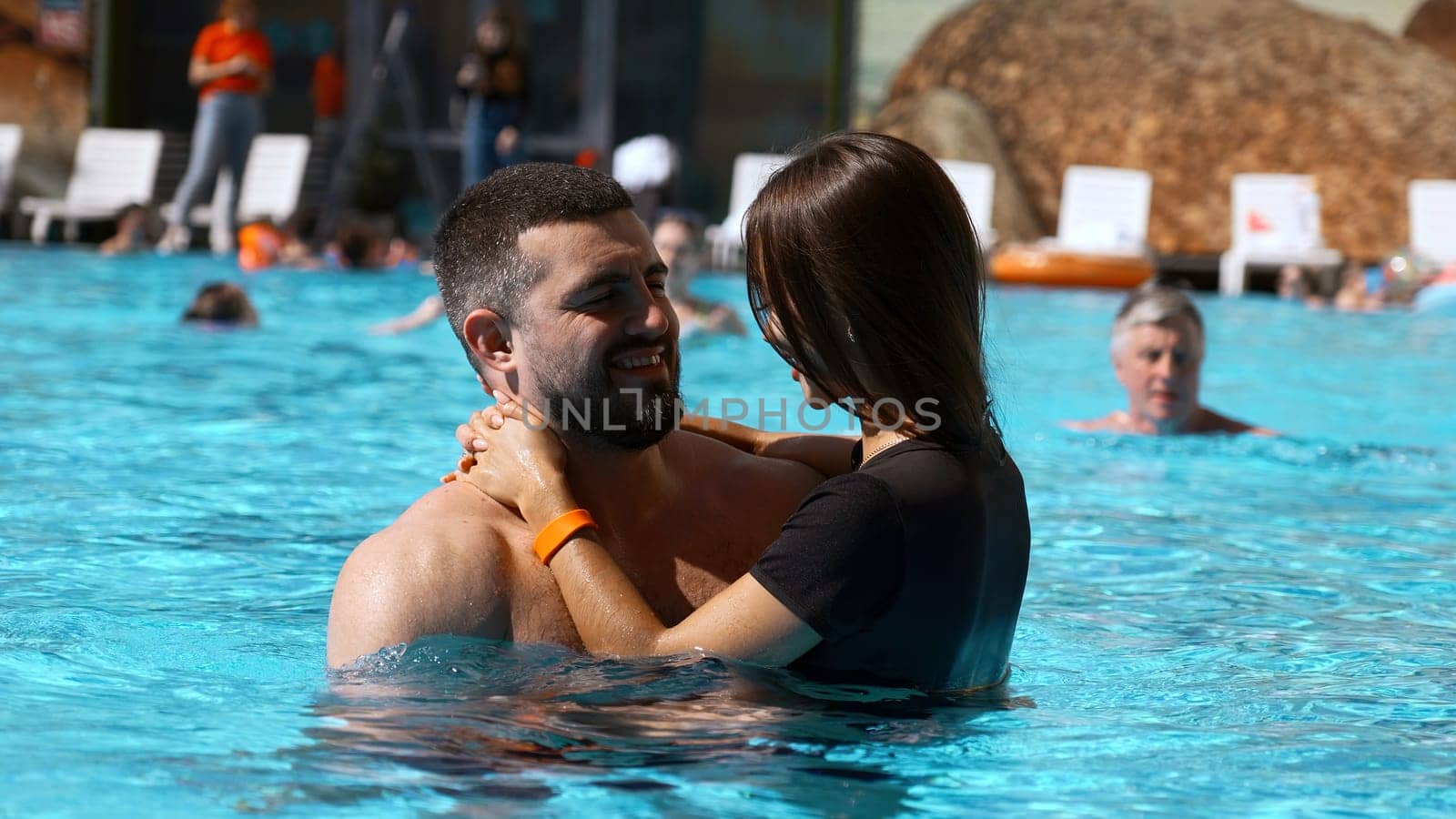 Young woman and man relaxing in resort pool. Clip. Couple enjoying holidays at luxury resort