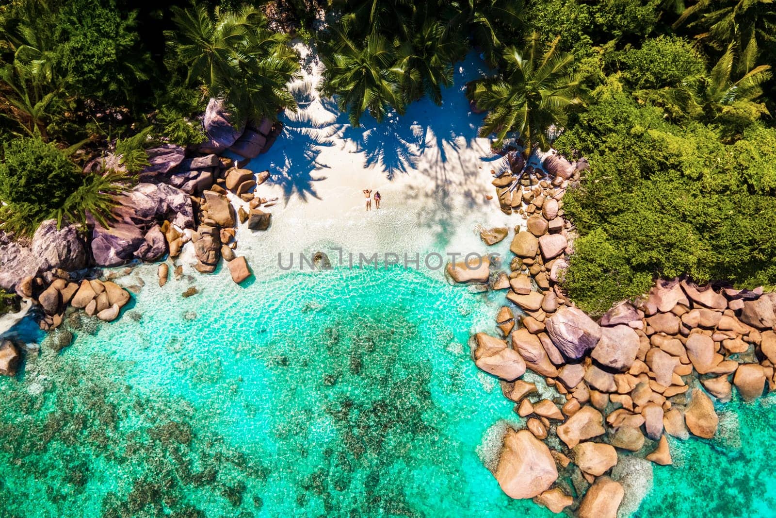 Praslin Seychelles tropical island with white beaches and palm trees, a couple of men and women mid age on vacation at Seychelles Anse Lazio Beach Praslin Seychelles