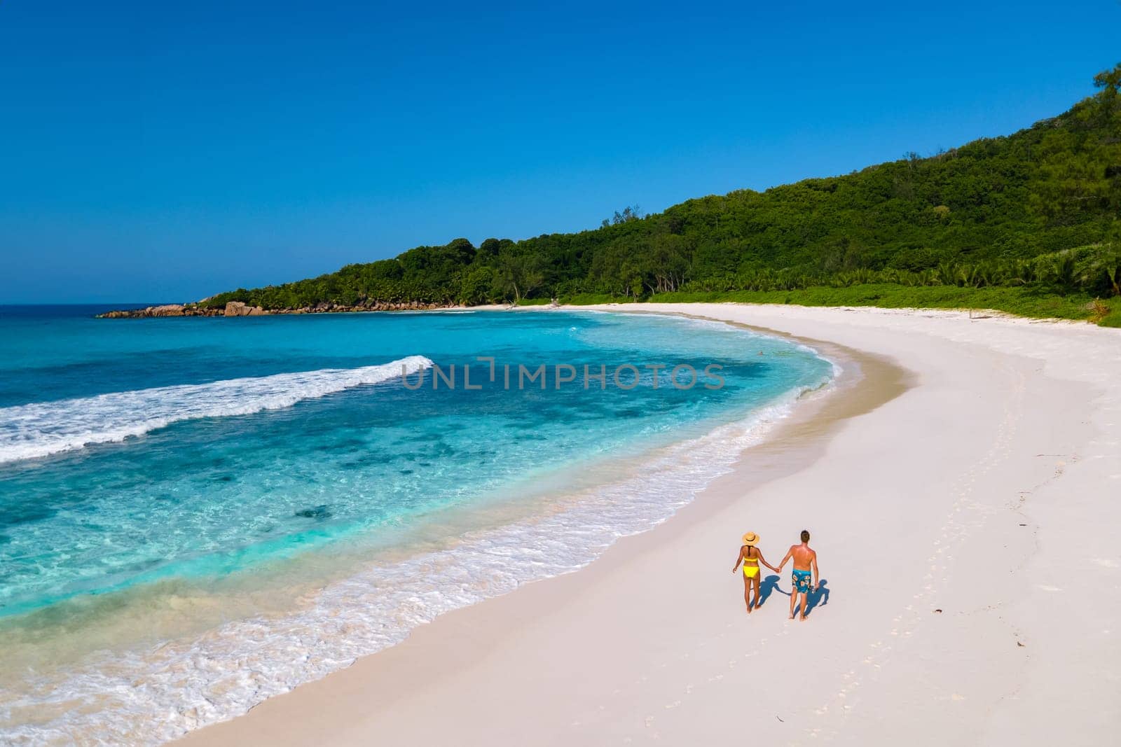 Anse Cocos beach, La Digue Island, Seyshelles, Drone aerial view of La Digue Seychelles bird eye view, couple men and woman walking at the beach during sunset at a luxury vacation by fokkebok