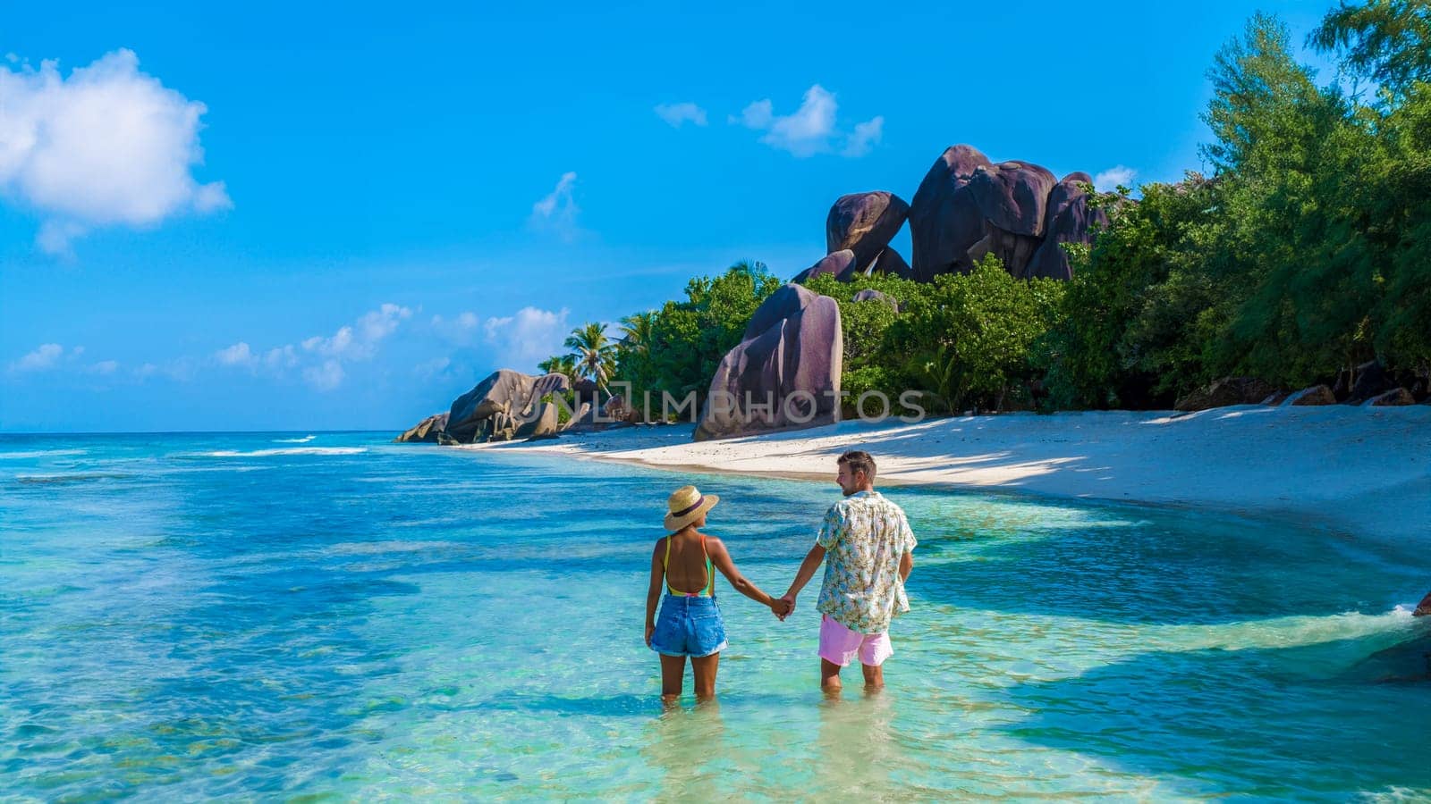 Anse Source d'Argent, La Digue Seychelles, a young couple of men and women on a tropical beach during a luxury vacation in Seychelles.