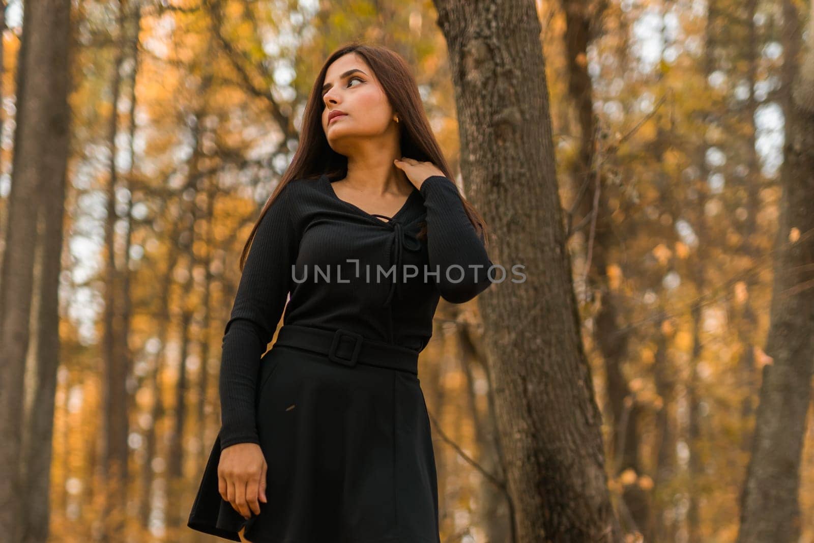 Close up portrait of pretty indian young woman enjoying warm autumn sunny day vacation outdoors. Generation z and gen z concept. Fall Season.