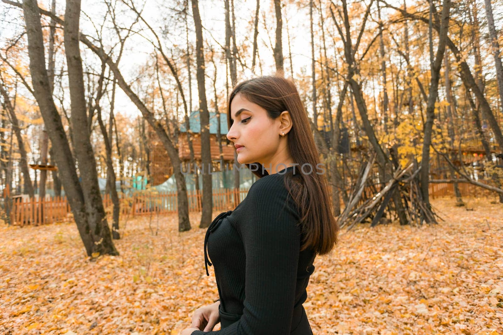 Close-up portrait of diversity young beautiful confident Indian Asian woman in black dress in fall outdoor copy space mockup. Happy and natural smiling female. Generation z and gen z youth concept by Satura86