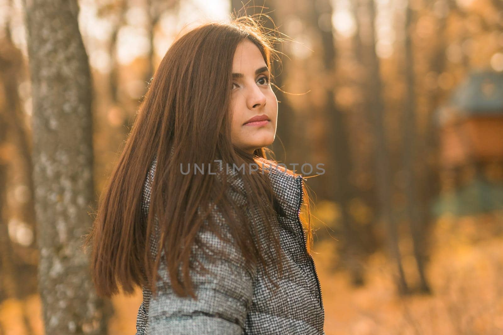 Close up portrait of pretty indian young woman enjoying warm autumn sunny day vacation outdoors. Generation z and gen z concept. Fall Season.