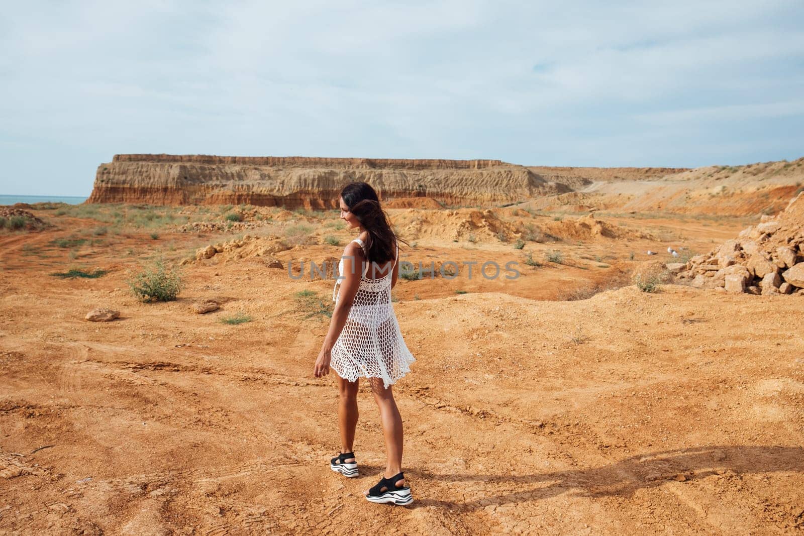 Woman on a walk in a sand quarry by Simakov