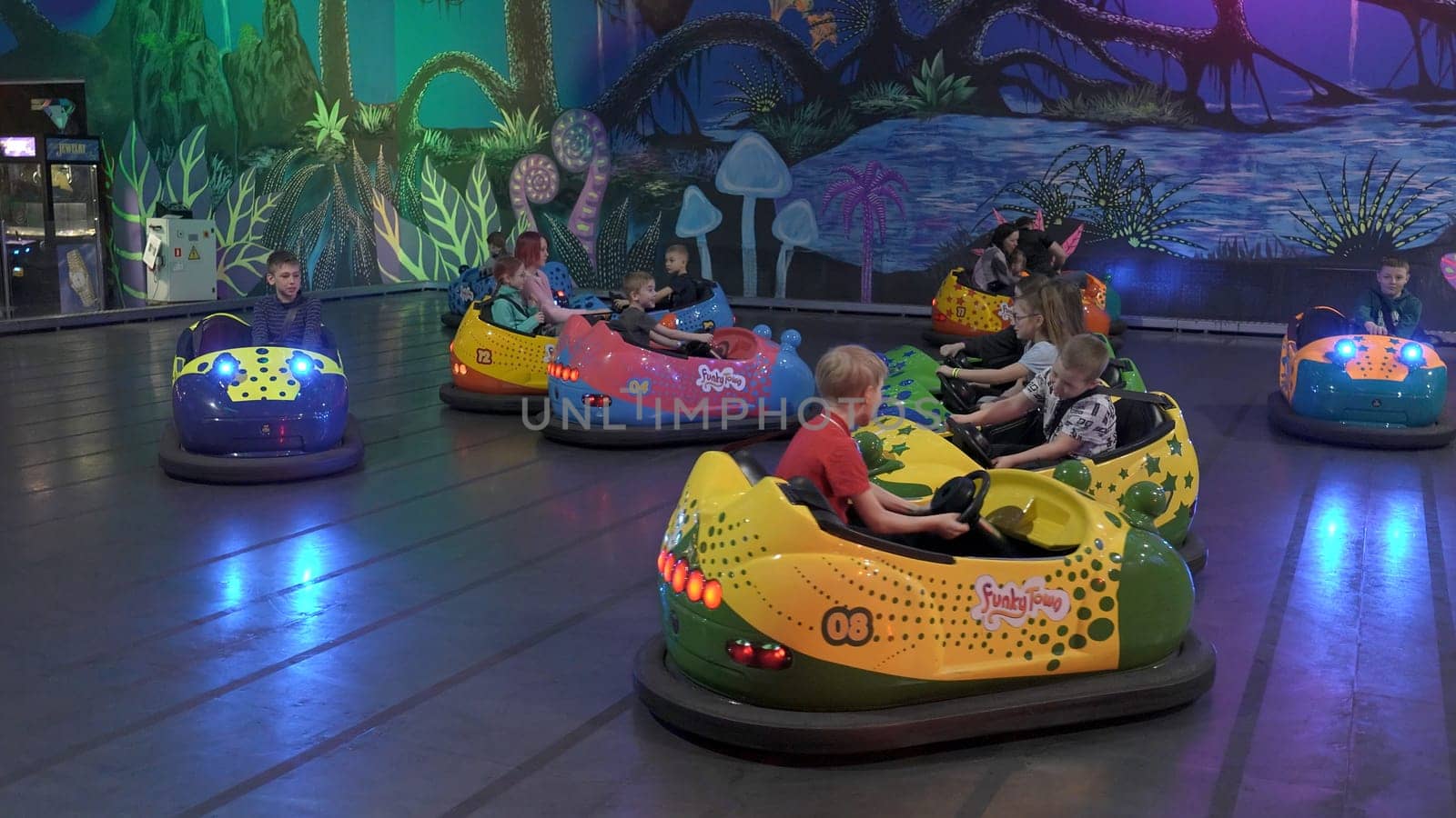 Serbia, Belgrade - June 20, 2023: Children on attraction with cars. Clip. Children ride on bumper car attraction. A lot of children are relaxing at weekend in amusement park with pushing cars by Mediawhalestock