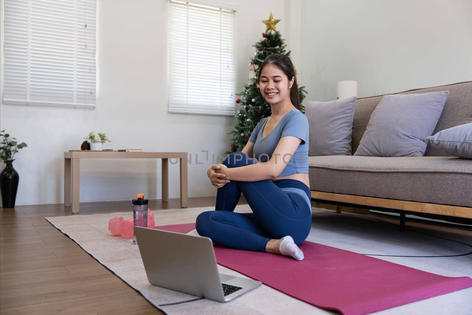 Young Asian sporty fitness woman coach do practice video online training yoga laptop in living room at home.