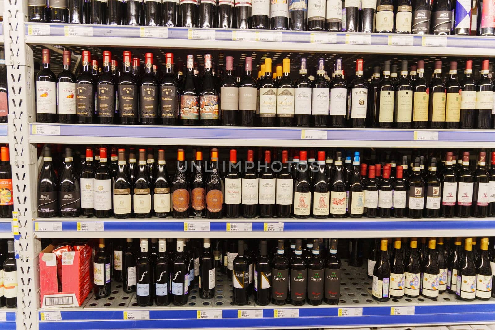 Tyumen, Russia-December 11, 2023: Collection of wines in a luxury alcohol store. Bottles of various wines are beautifully placed on the counter. by darksoul72