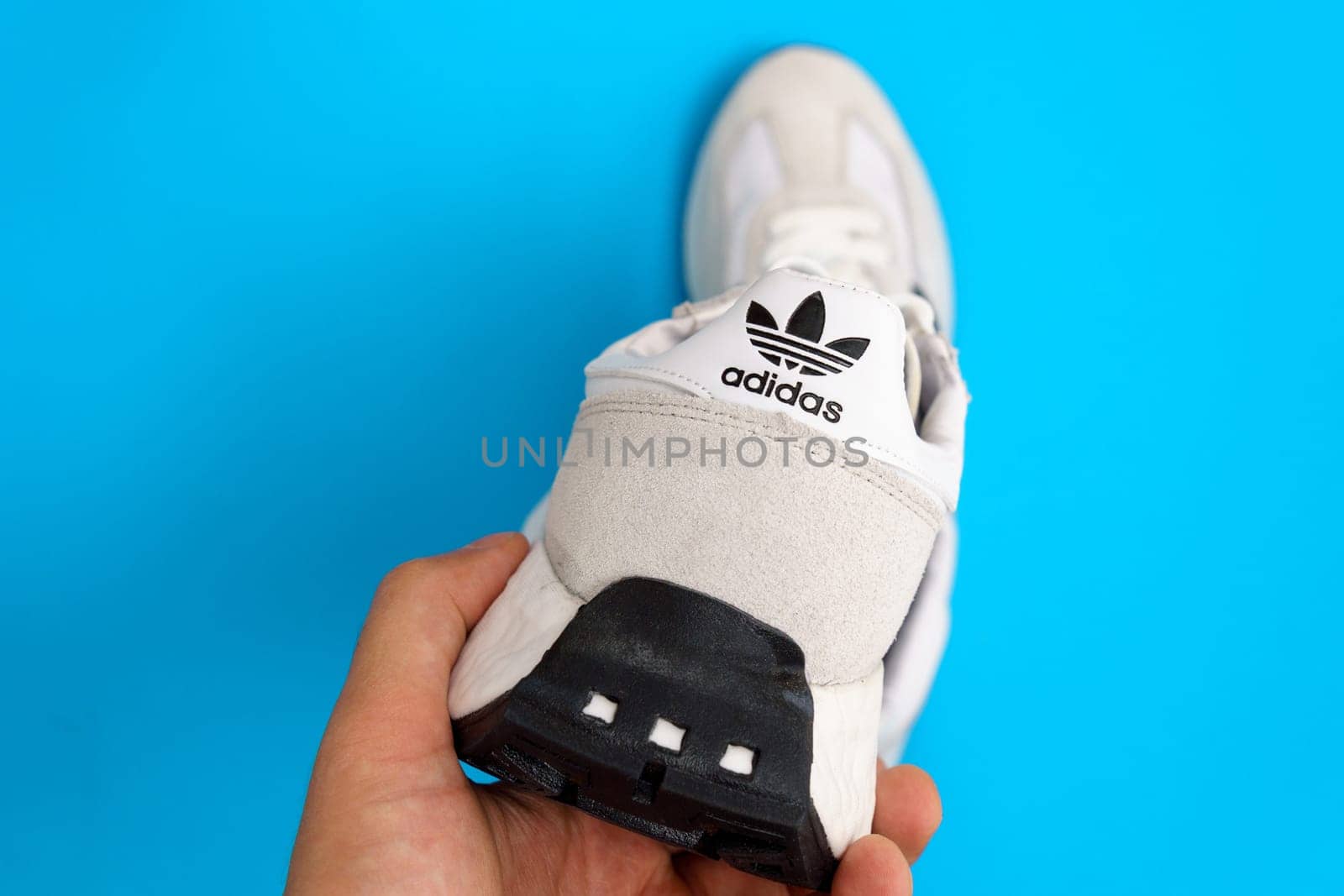 Tyumen, Russia-October 03, 2023: White adidas sneakers on blue background. New clean sneakers