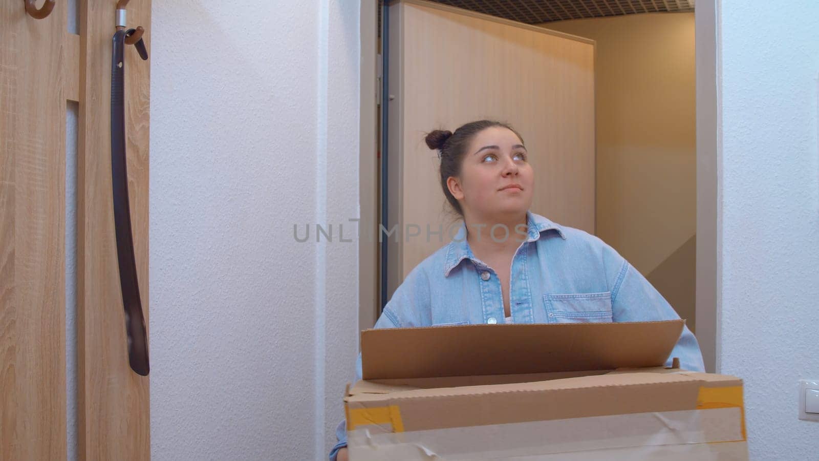 A beautiful woman entering the apartment. Media. A pretty woman with her own hair who enters her apartment. High quality 4k footage