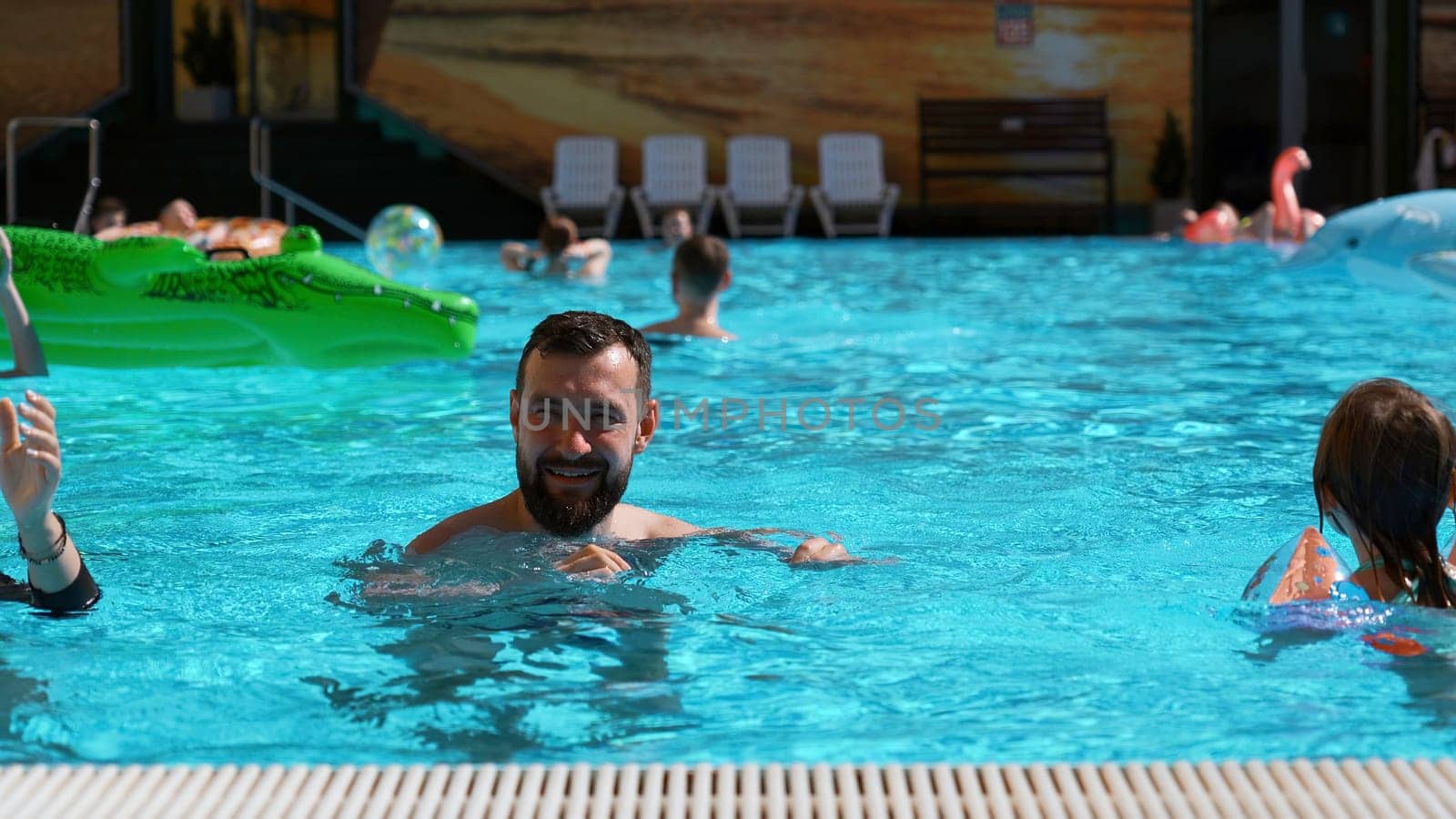 Happy family spending time in outdoors hotel swimming pool. Clip. Concept of travelling with children