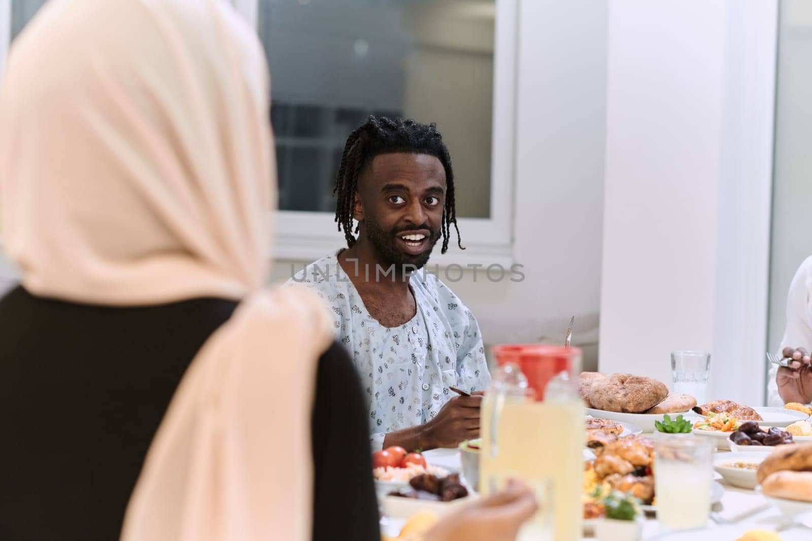 A traditional and diverse Muslim family comes together to share a delicious iftar meal during the sacred month of Ramadan, embodying the essence of familial joy, cultural richness, and spiritual unity in their shared celebration by dotshock