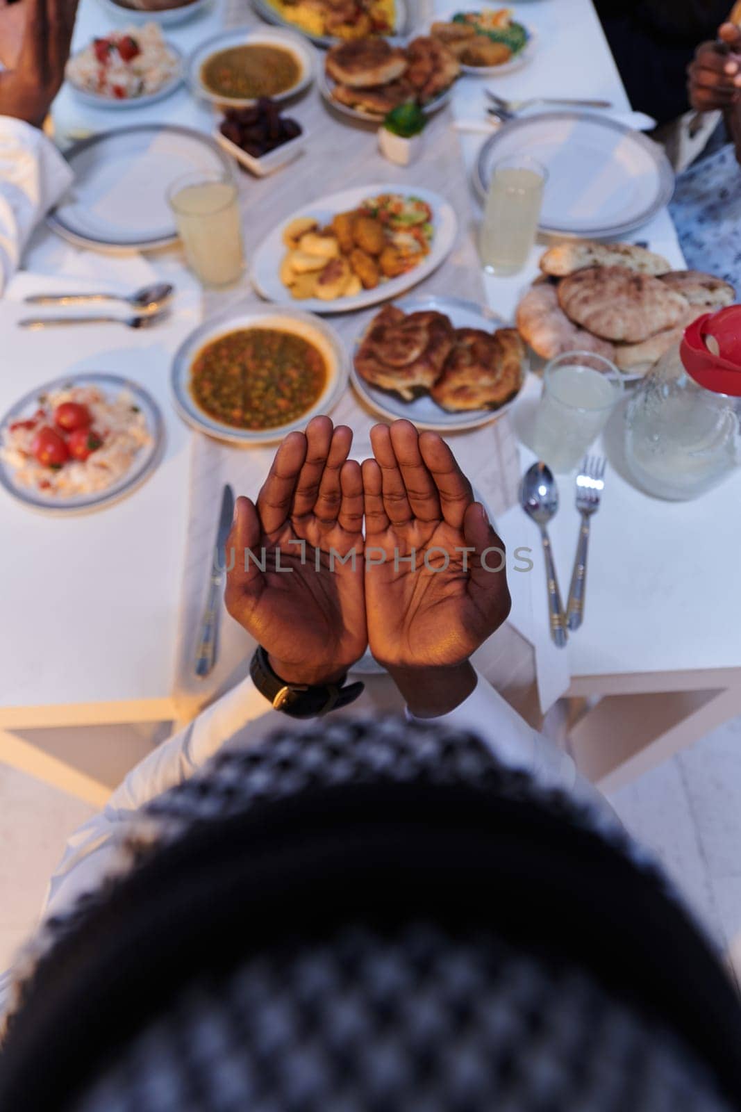 In the sacred month of Ramadan, a diverse Muslim family comes together in spiritual unity, fervently praying to God before breaking their fast, capturing a moment of collective devotion, cultural diversity, and familial joy in the midst of the holy celebration by dotshock