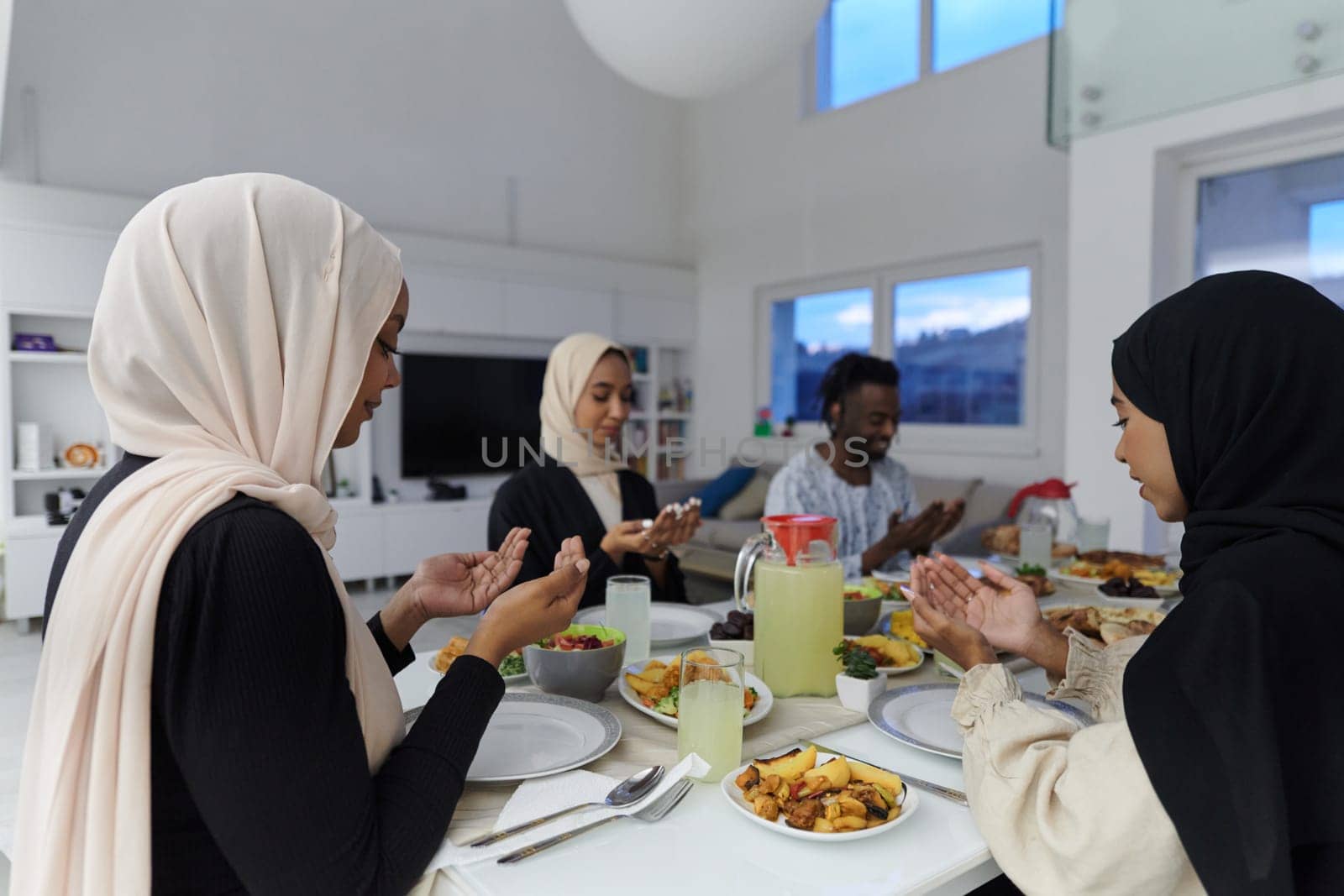 In the sacred month of Ramadan, a diverse Muslim family comes together in spiritual unity, fervently praying to God before breaking their fast, capturing a moment of collective devotion, cultural diversity, and familial joy in the midst of the holy celebration by dotshock