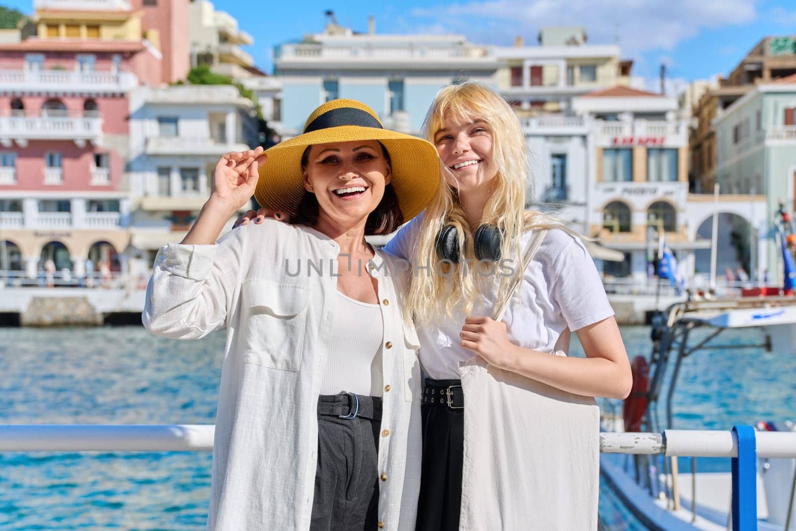 Portrait of happy smiling mom and teenage daughter hugging together. Women tourists resting in summer European tourist town. Family, parent teen relationship, travel, communication