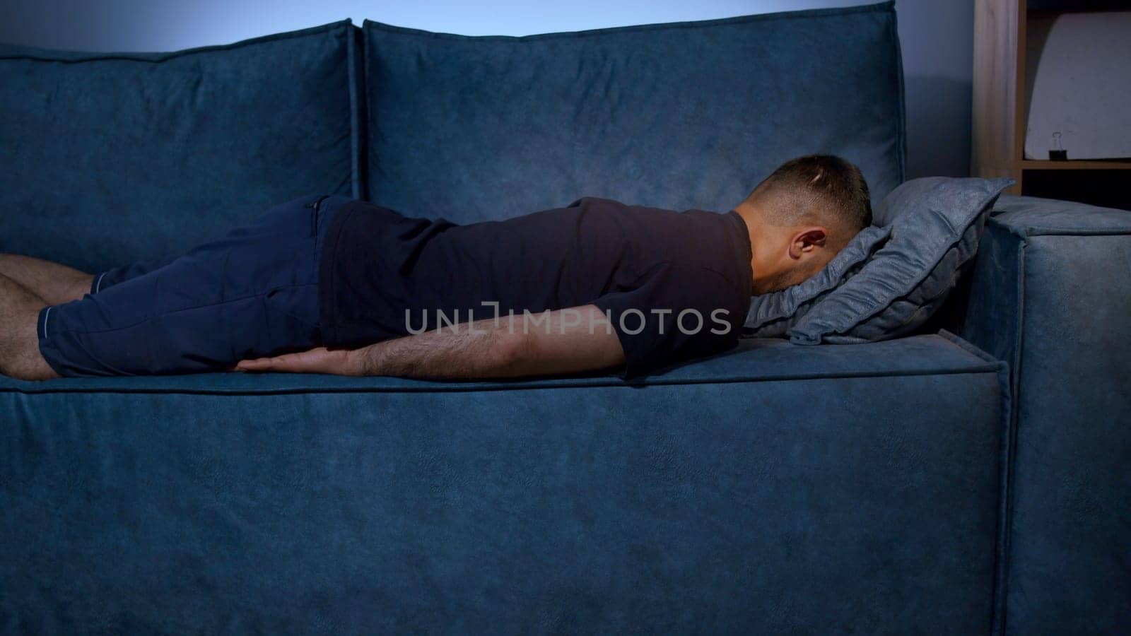 Tired boy slumping on couch feeling listless. Media. Feeling depressed, lack of motivation, sadness, boredom. Exhausted, he collapses on the couch from stress