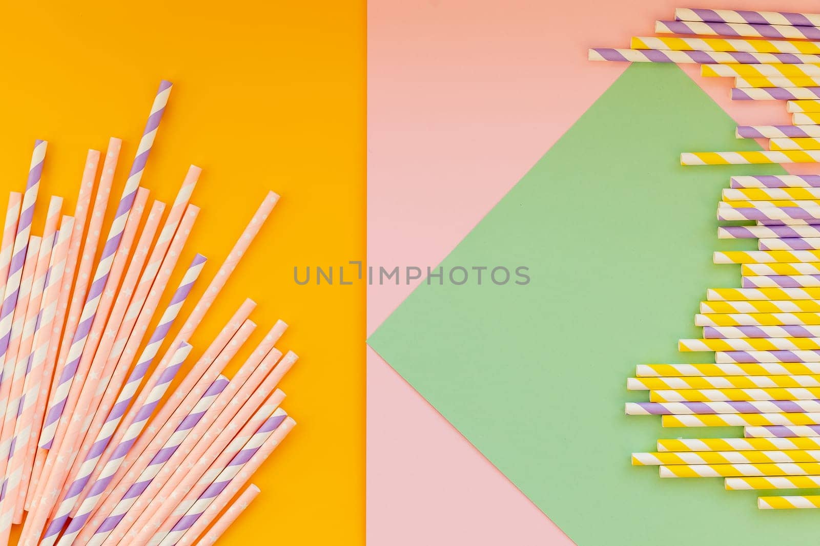 Drinking paper straws on bright background,copy space. Top view of colored paper disposable eco-friendly straws for summer cocktails.biodegradable eco-friendly paper straws. cocktail tubes. by YuliaYaspe1979