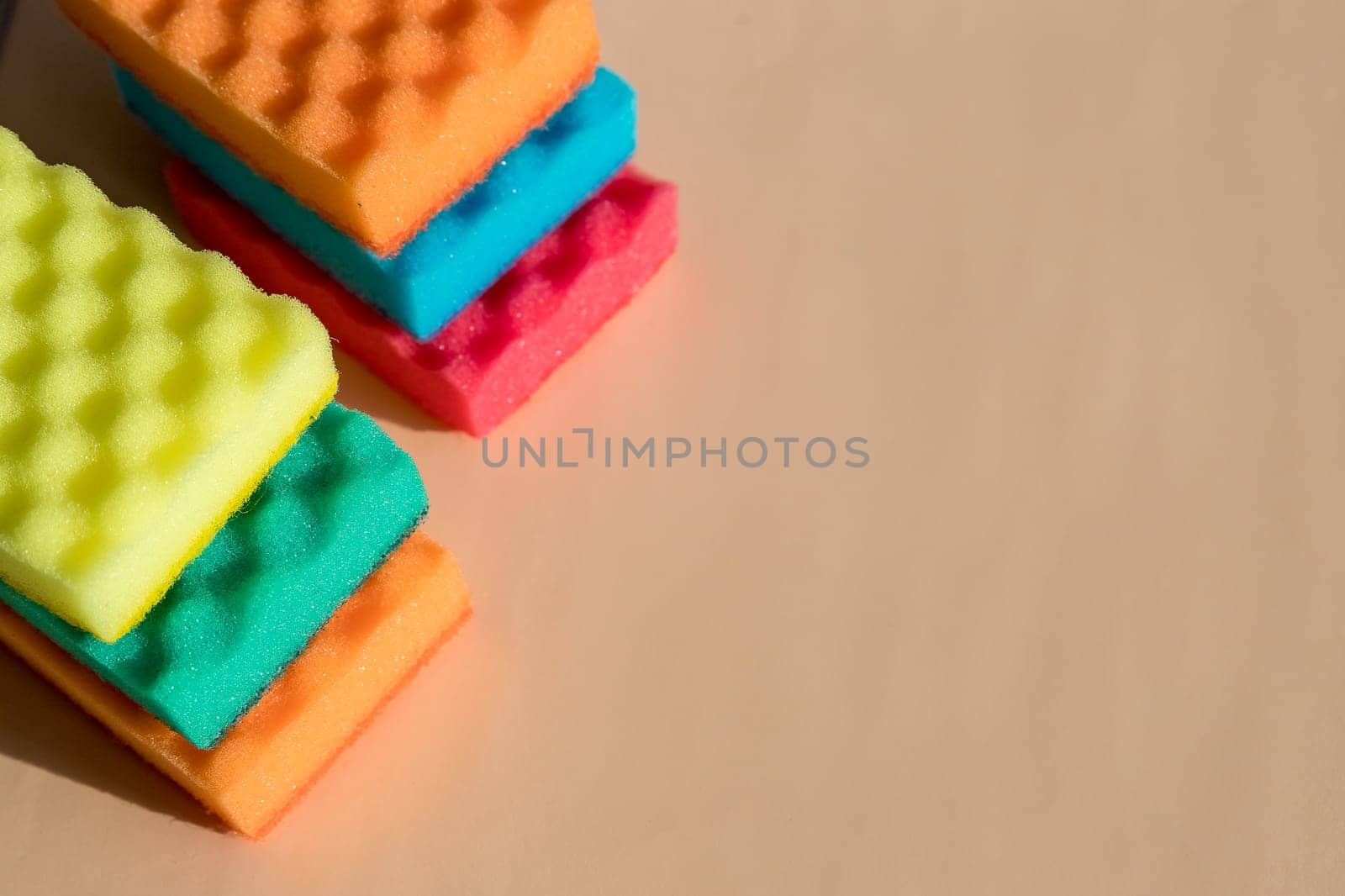 Brightly colored sponges on beige background with copy space.Bright colored sponges for washing dishes, cleaning the bathroom and other household needs.Cleaning sponge.household concept by YuliaYaspe1979