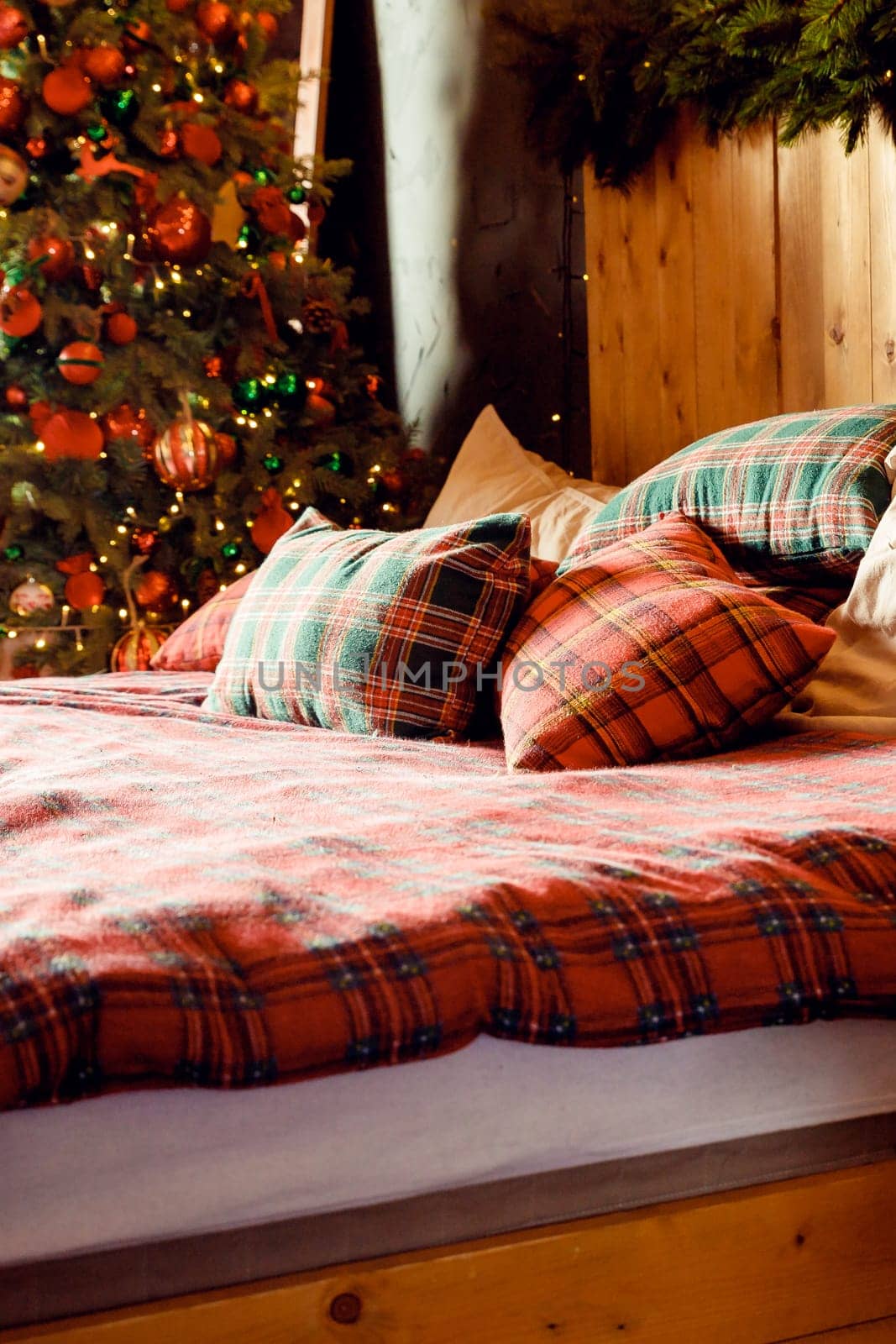 Winter Xmas Hygge home decor. Festive cozy bedroom in Skandinavian style with bed and many pillows, decorated christmas tree with gifts. Concept new year and holidays. Interior design bedroom. by YuliaYaspe1979