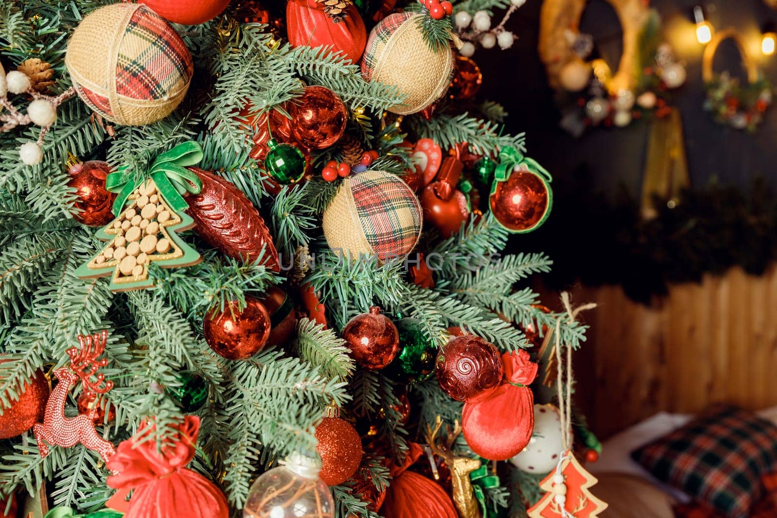 Christmas decorations on the holiday tree.Many colorful balls garland glowing lamps and red berries on the branches are sprinkled with snow.Festive traditional seamless background for the New Year by YuliaYaspe1979