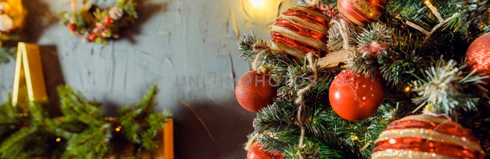 Christmas decorations on the holiday tree.Many colorful balls garland glowing lamps and red berries on the branches are sprinkled with snow.