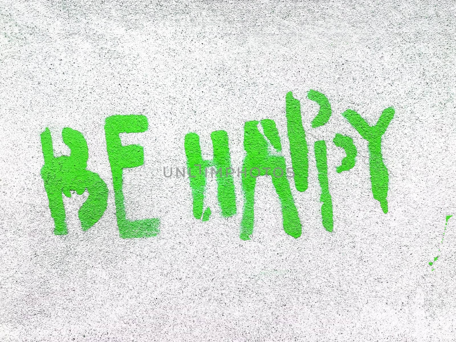 Green Be Happy written in graffiti style with rough texture isolated on gray background.