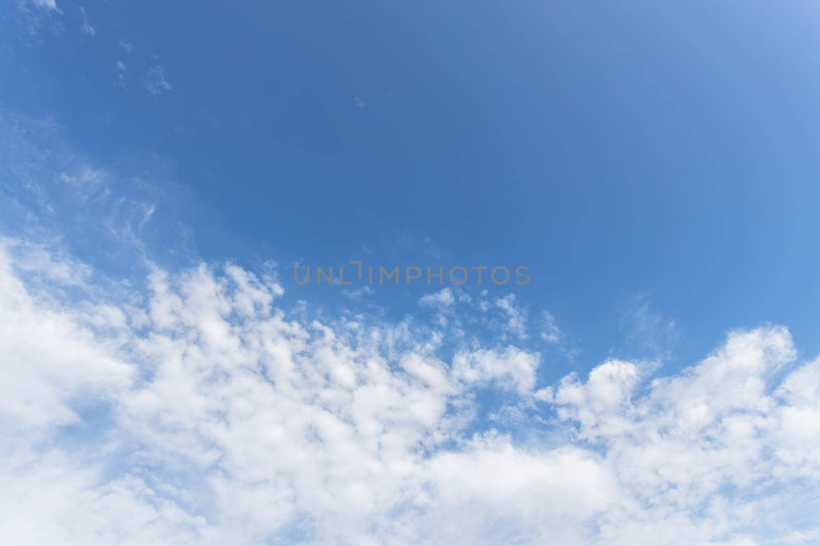Beautiful full clouds on blue sky background. Elegant white clouds in daylight. Sunny day.