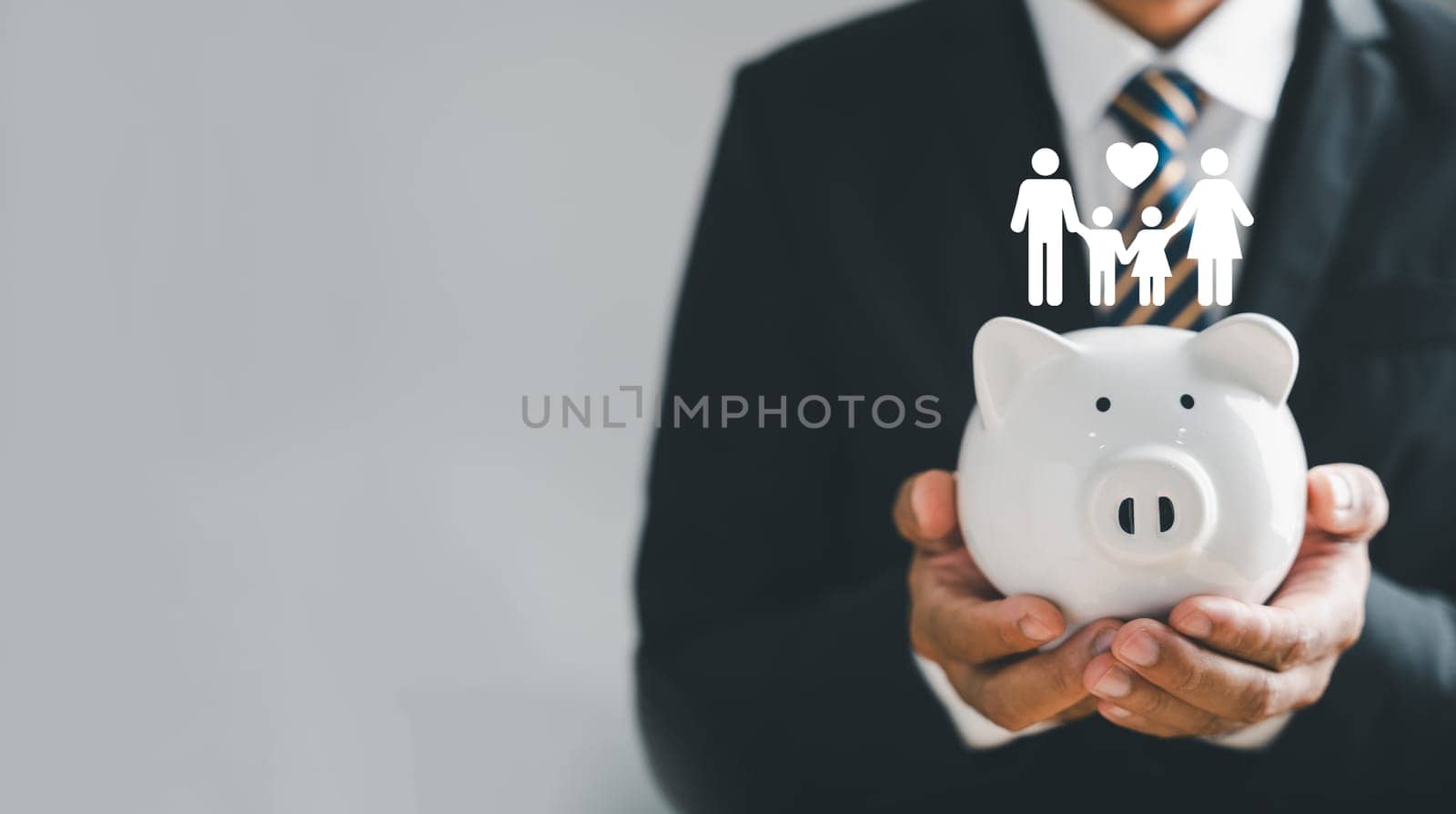 Businessman protects piggybank, holds family icon in hand, symbolizing saving, donation, family finance strategies. Depicting mes of charity, fundraising, superannuation, and financial crisis concept.