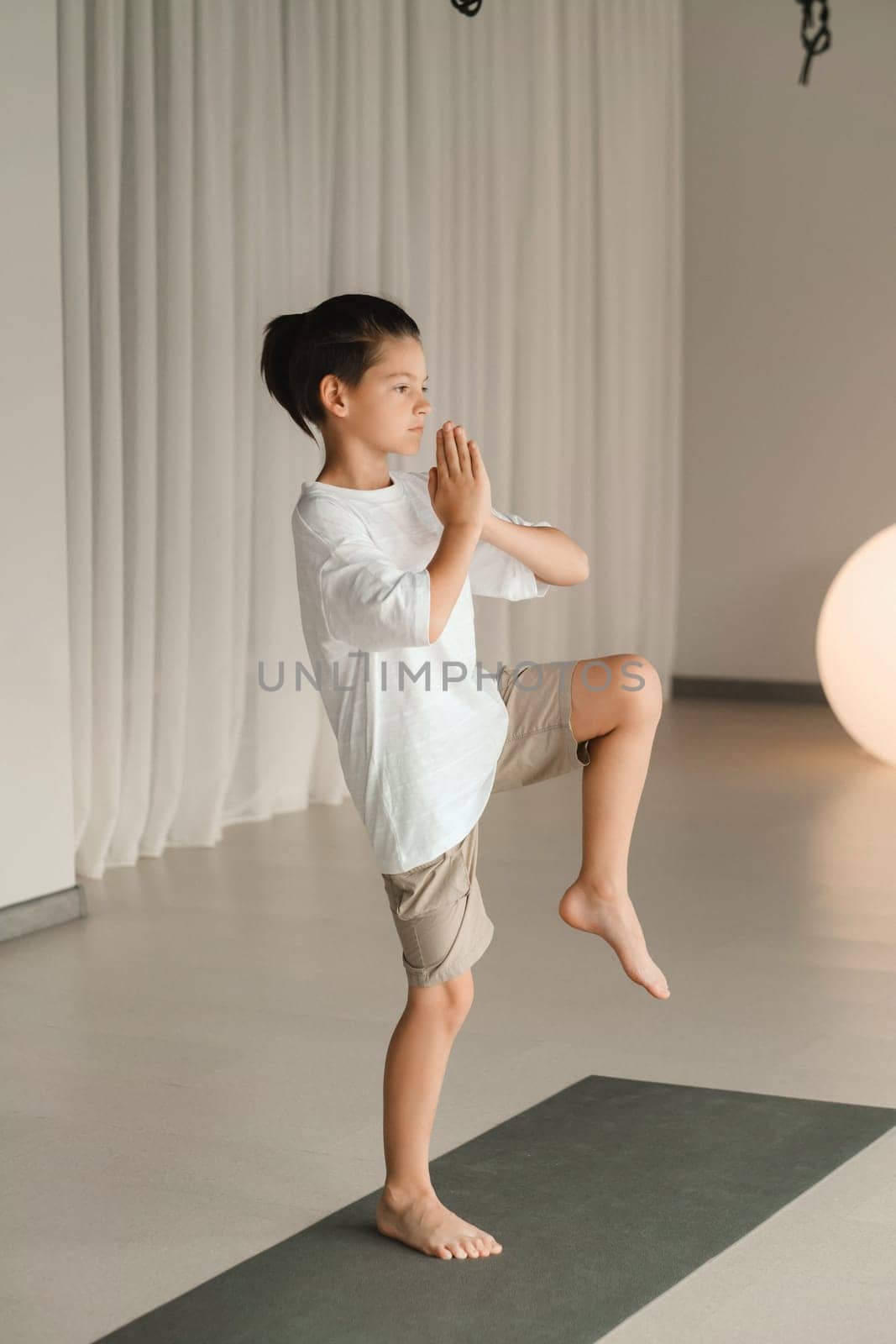 A child practices yoga poses indoors. Children's yoga.