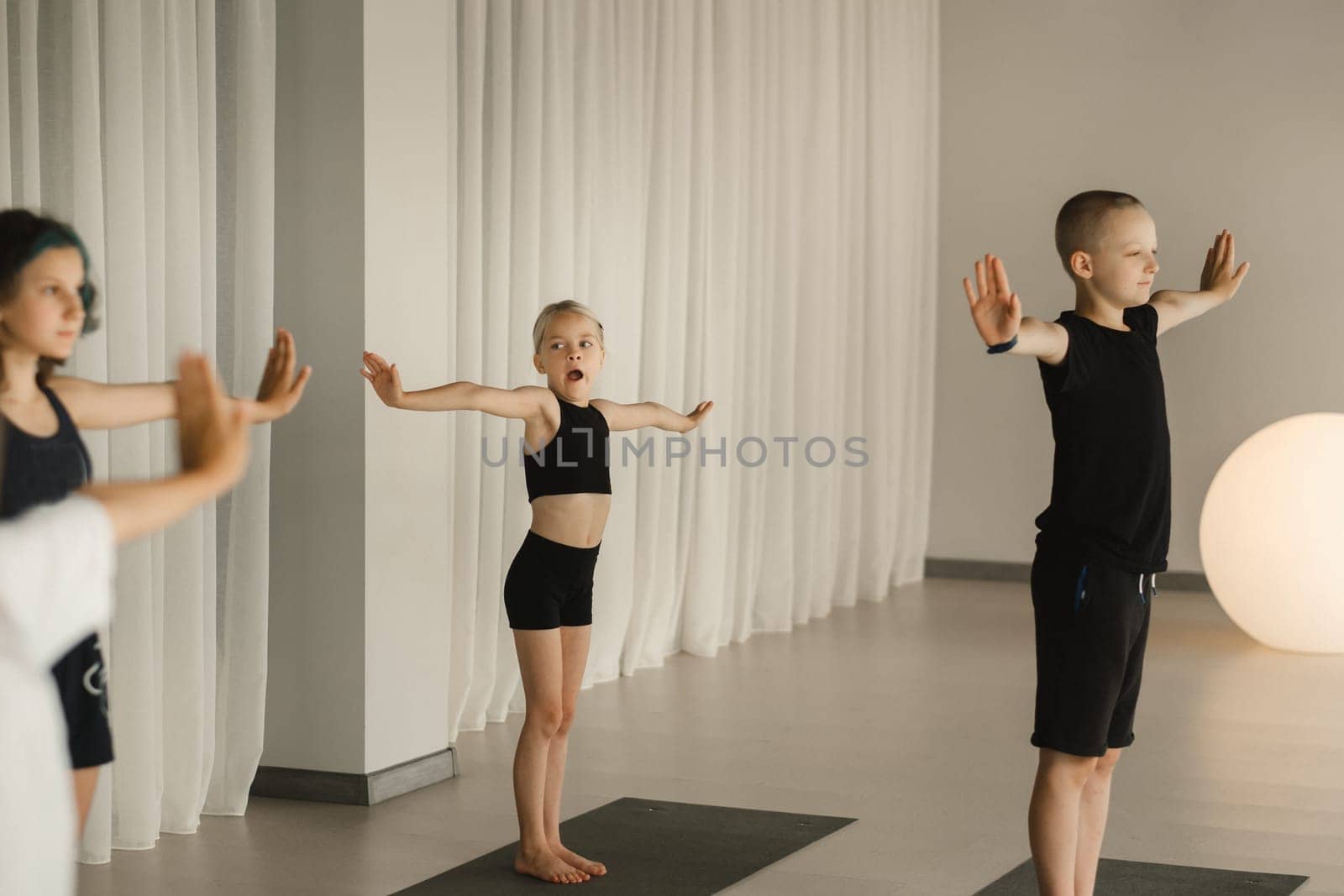 Children do Yoga in the fitness room. Children's gymnastics by Lobachad