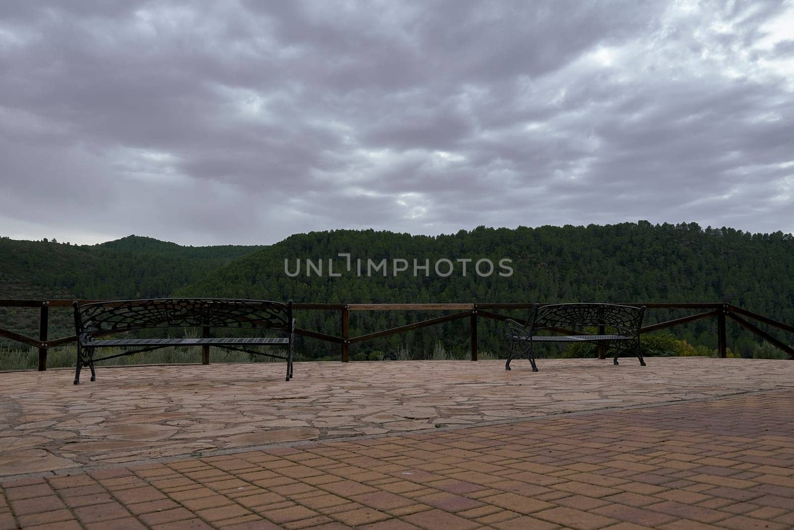 Two lonely benches in a fresh mountain landscape. No people, iron, forge, sun with clouds, pine forest, relaxation, go wood,
