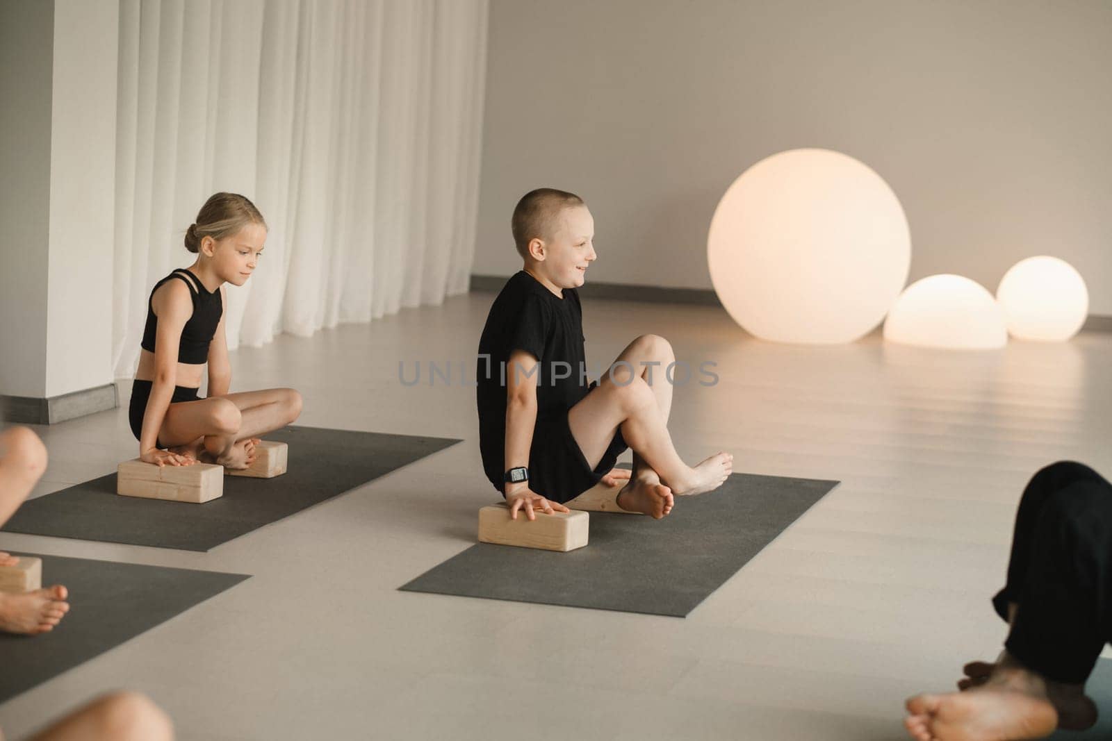 Children do yoga in the gym on support blocks. Children's gymnastics.