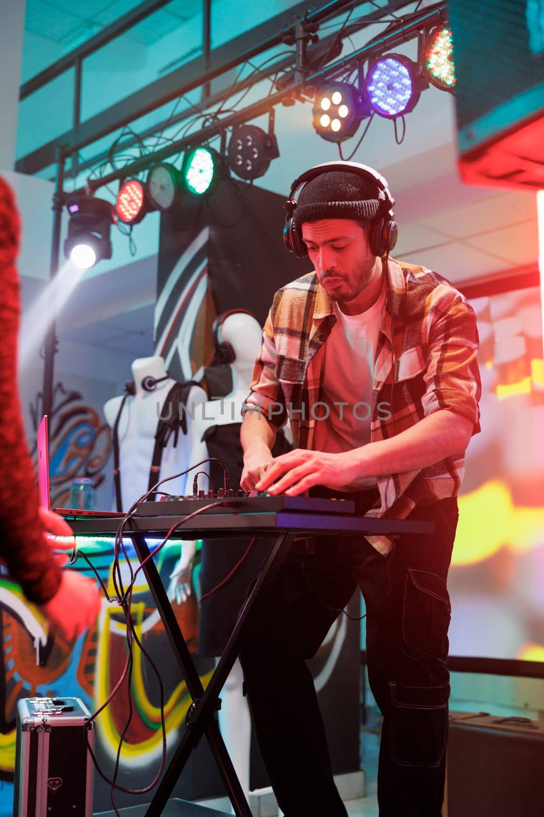 Performer playing techno music in club by DCStudio