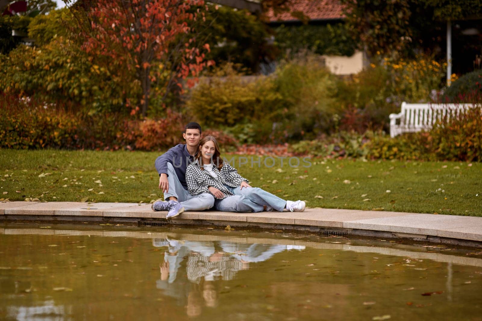 lovely young couple kissing outdoors in autumn. Loving couple walking in nature. Autumn mood. Happy man and woman hugging and kissing in autumn. Love. Fashionable couple outdoors. Fashion, people and lifestyle. Stylish couple in autumn outfit.