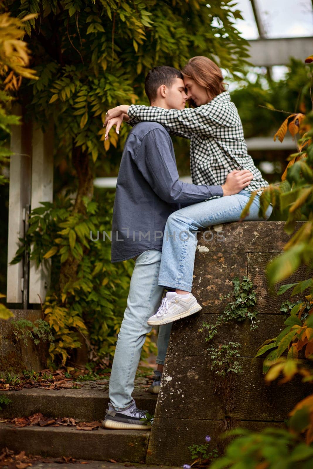 Young Cute Female Hugs Boyfriend. In Autumn Outdoor. Lovers Walking in Park. Attractive Funny Couple. Lovestory in Forest. Man and Woman. Cute Lovers in the Park. Family Concept. Happy Couple.