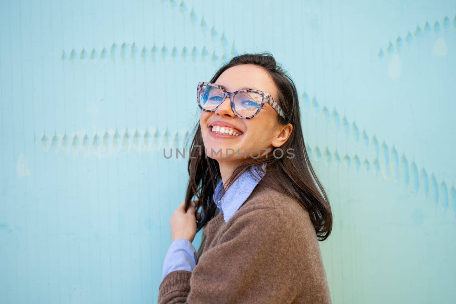 Woman wearing glasses and casual style smiles broadly outdoor by andreonegin