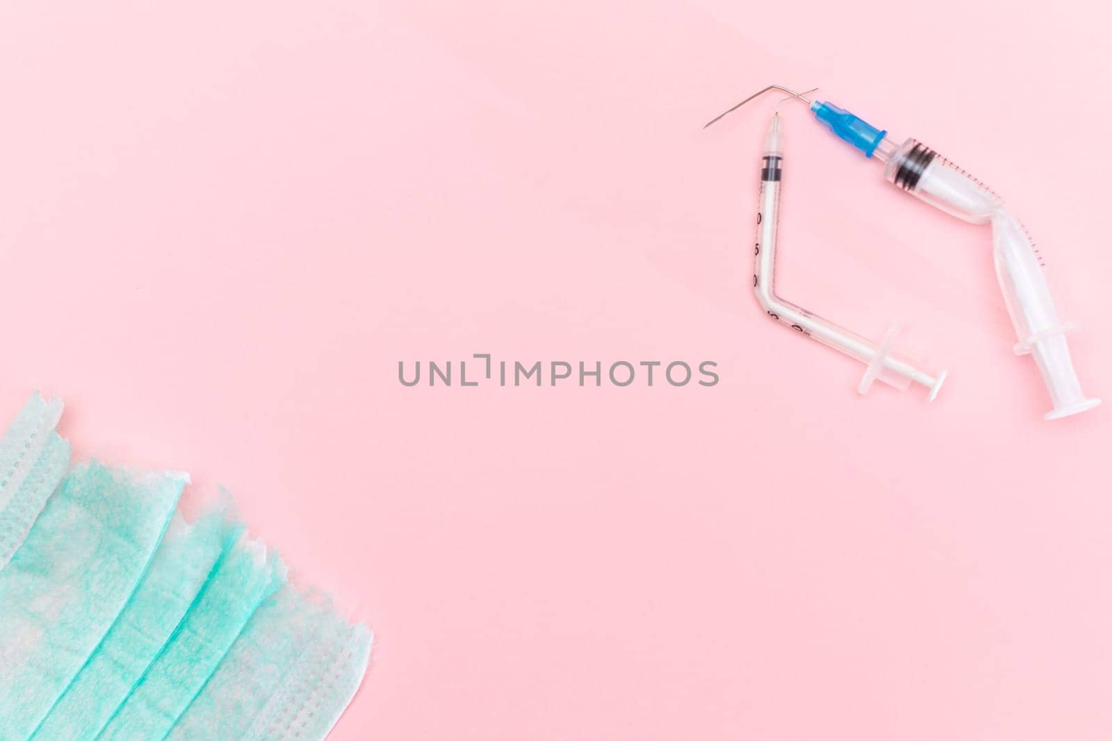 Broken Medical Syringe and Torn Medical Face Mask on the Pink Background by InfinitumProdux