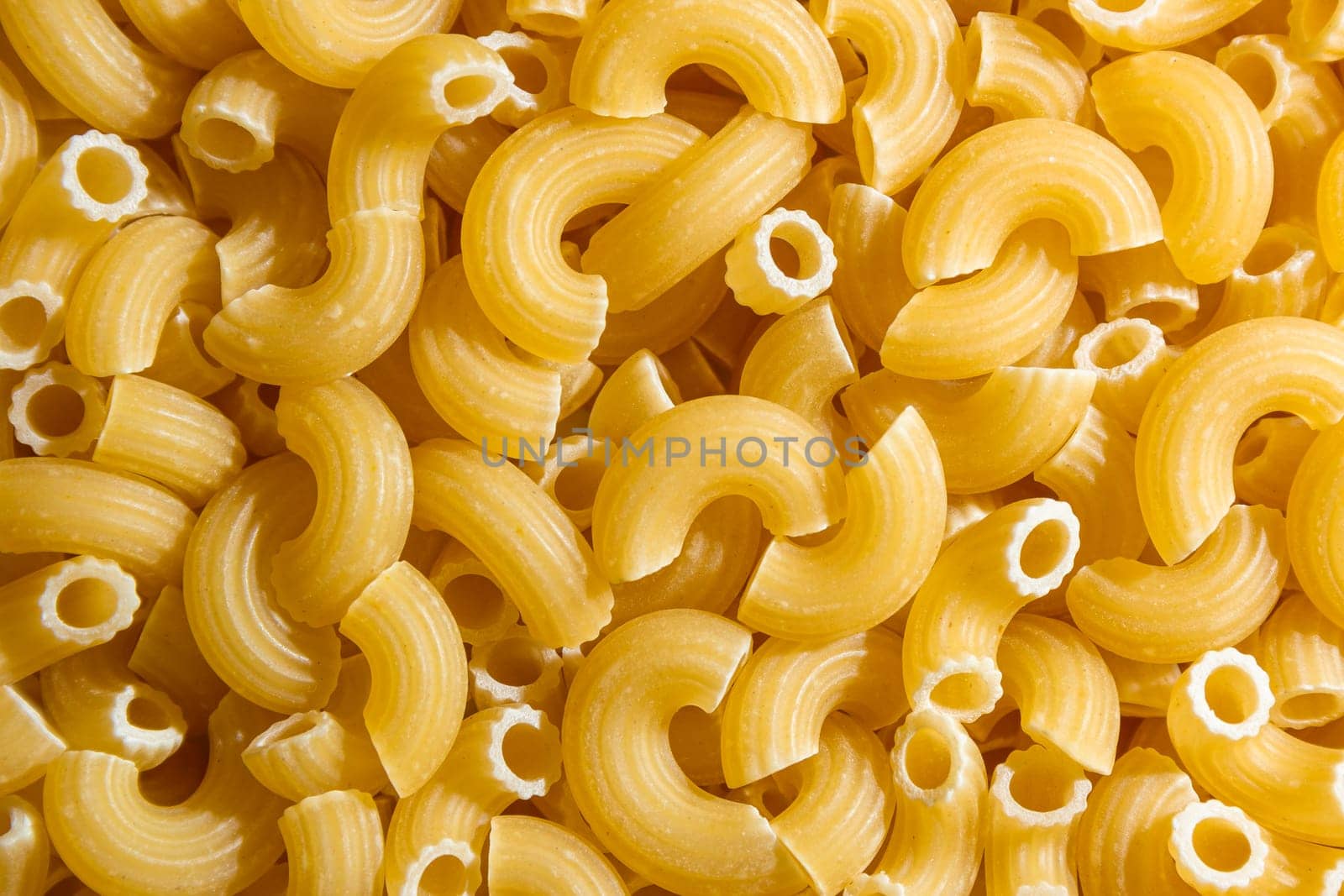 Uncooked Chifferi Rigati Pasta Background by InfinitumProdux