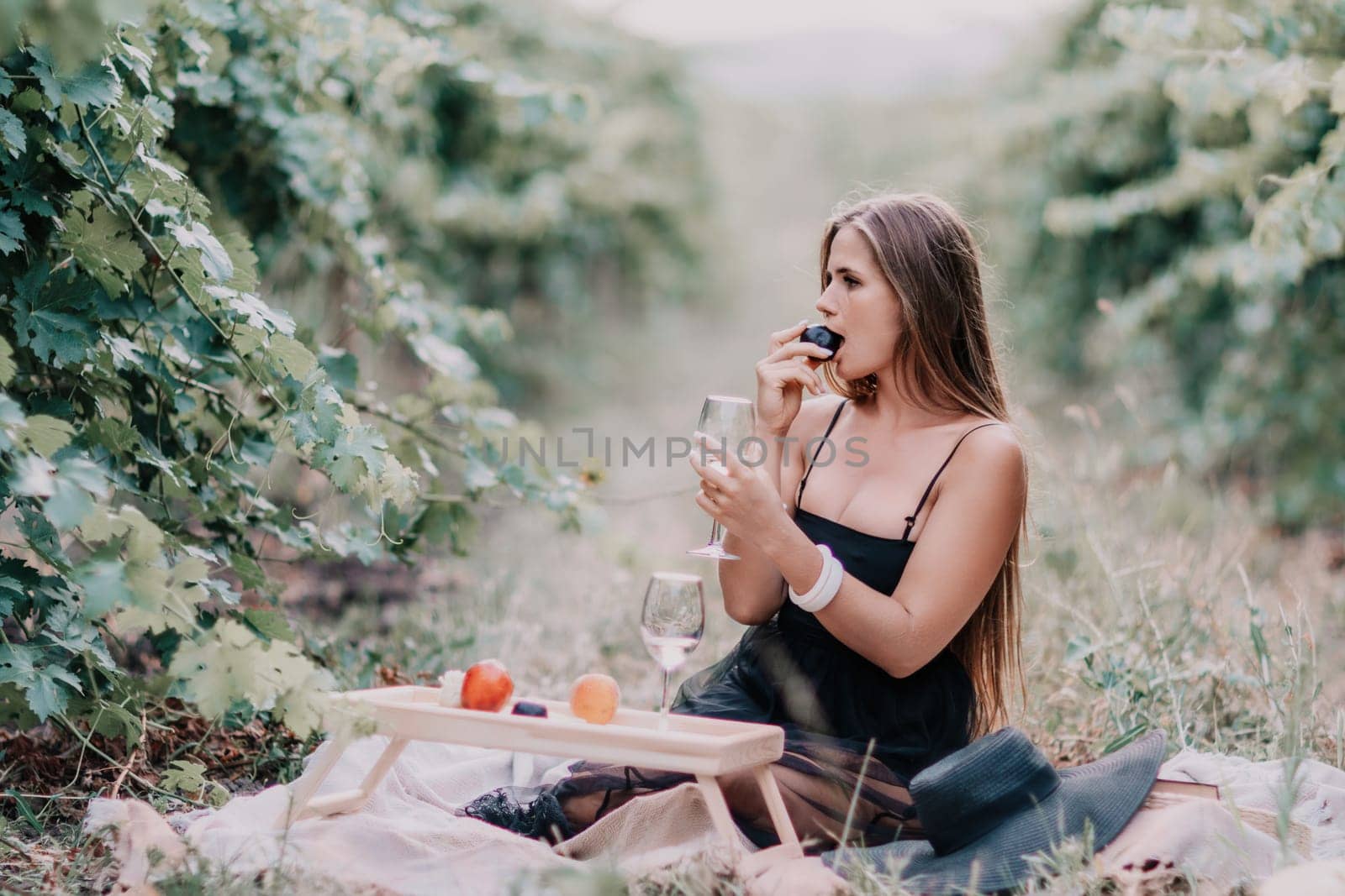 Picnic and wine tasting at sunset in the hills of Italy, Tuscany. Vineyards and open nature in the summer. Romantic dinner, fruit and wine.
